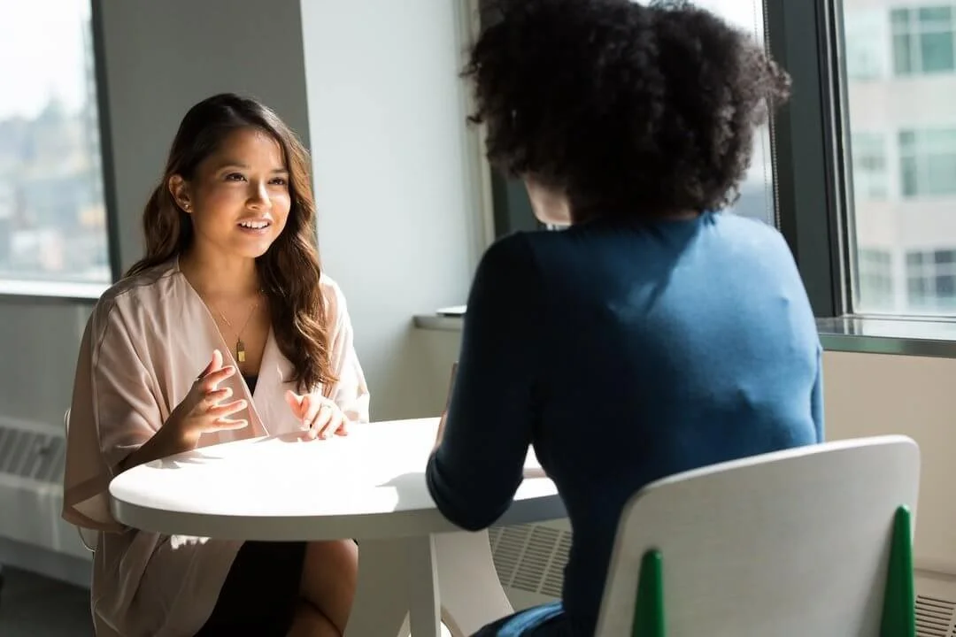 Two people engaged in a transformative coaching conversation, exploring personal growth and goal achievement.