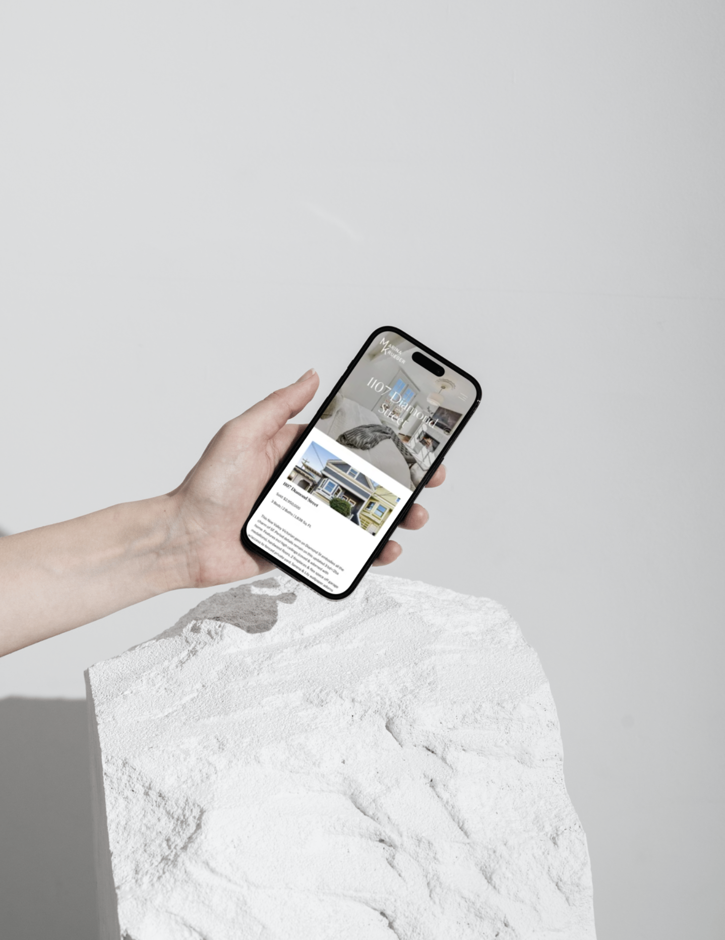 Person holding iPhone with Marina Krueger about page displayed
