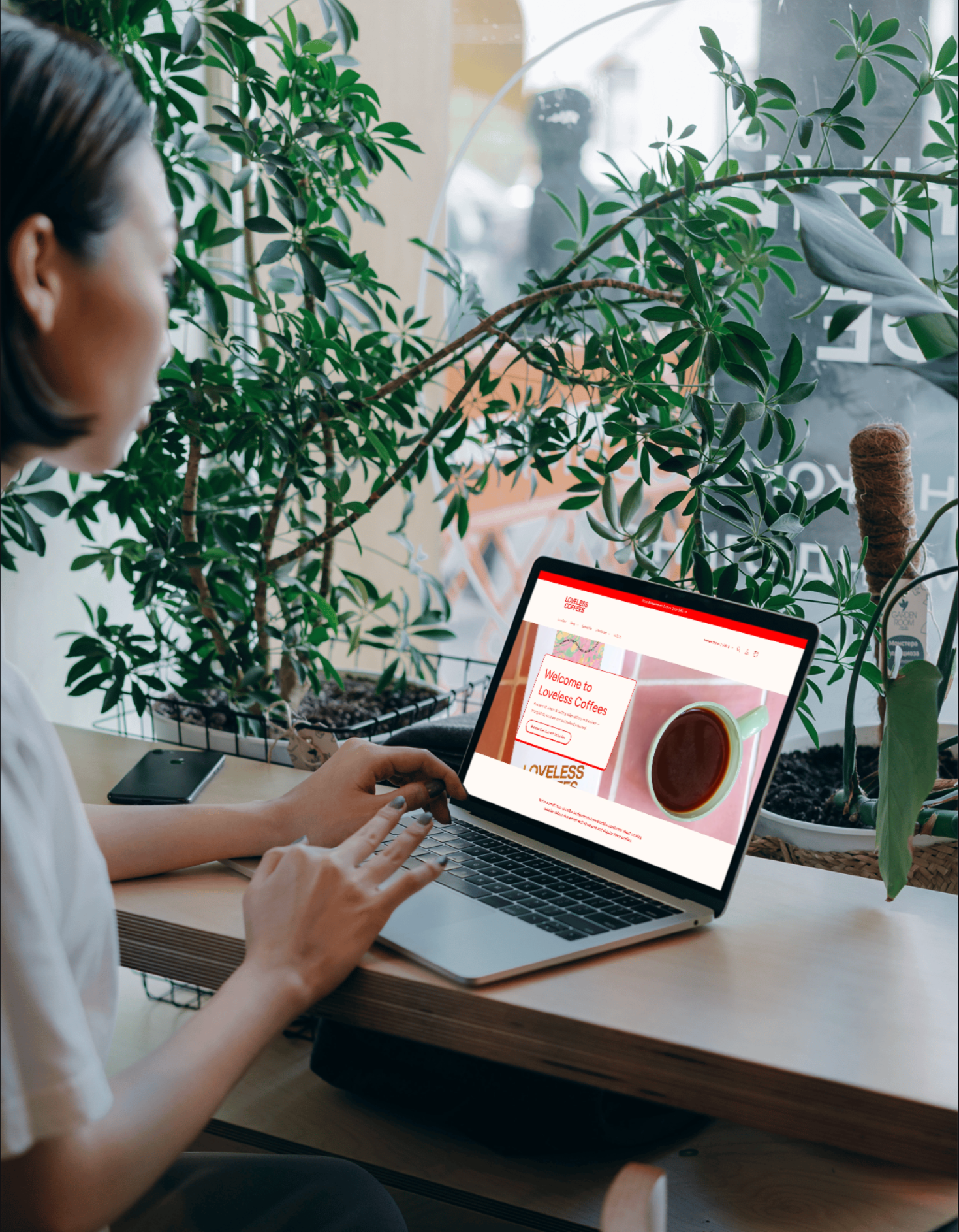 Woman on laptop with Loveless Coffees homepage open