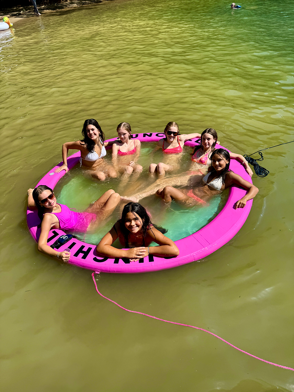 Girls on water hammock float.