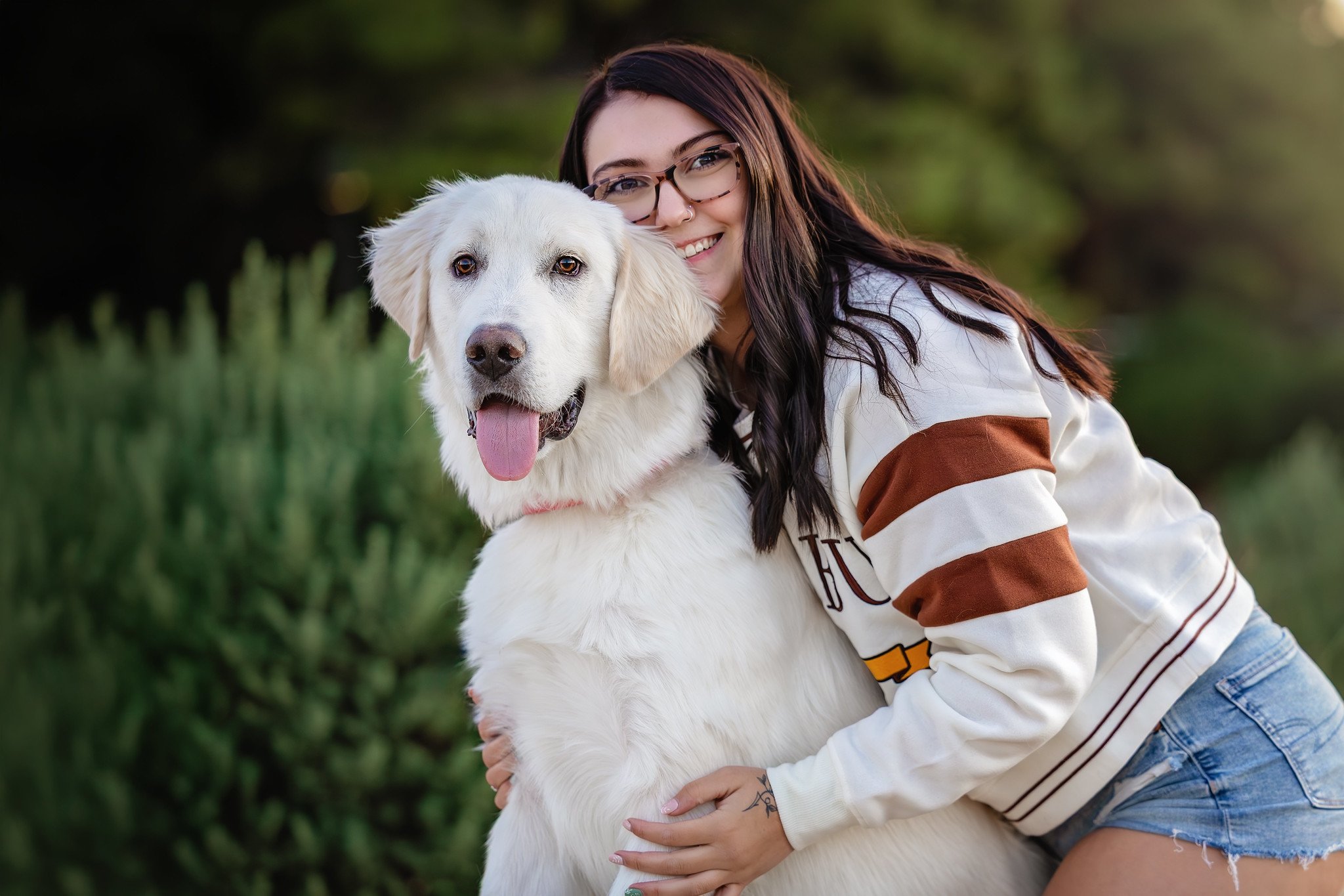 a girl hugging her white service dog puppy