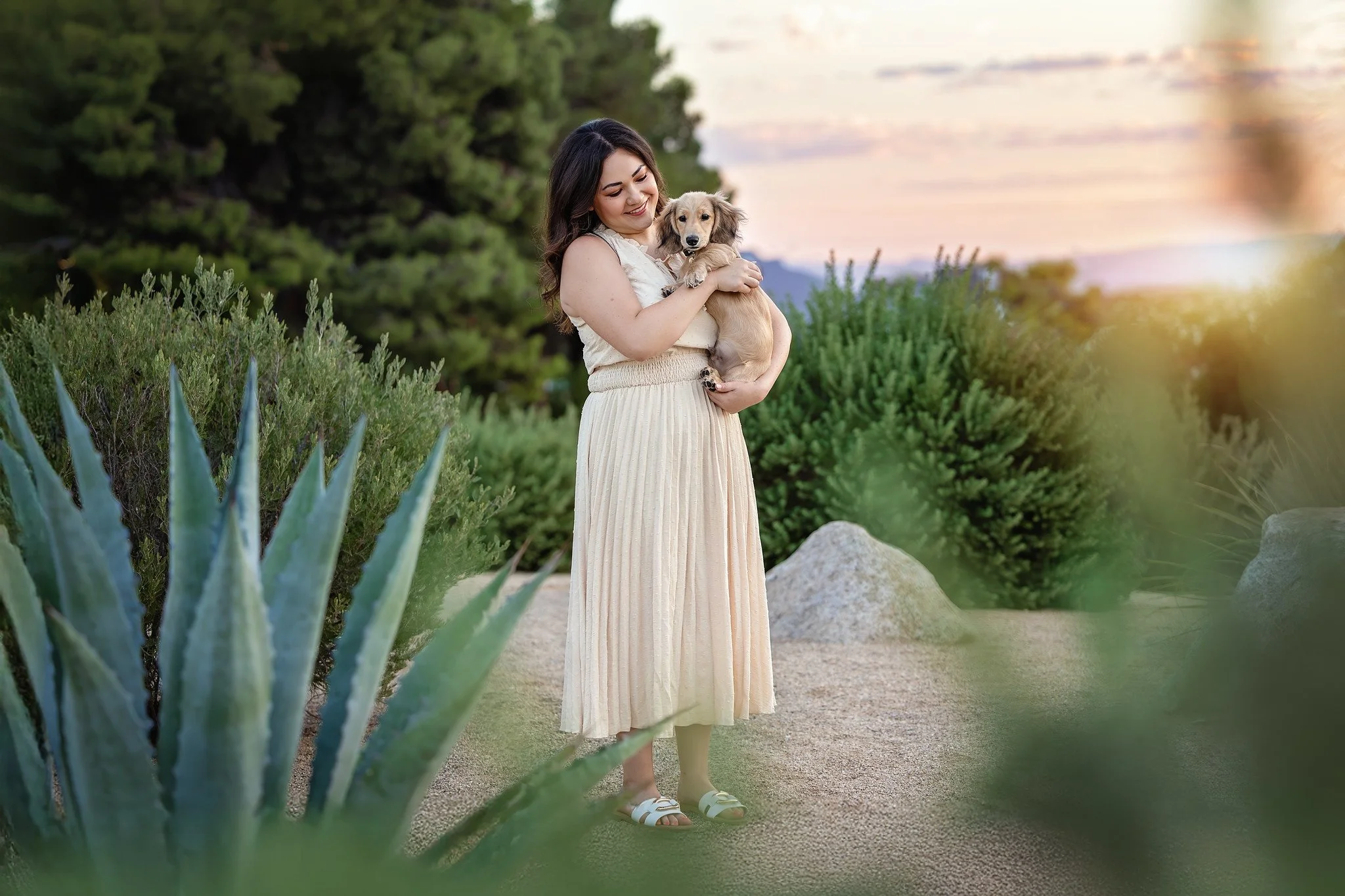 woman holding her cream colored dachshund puppy