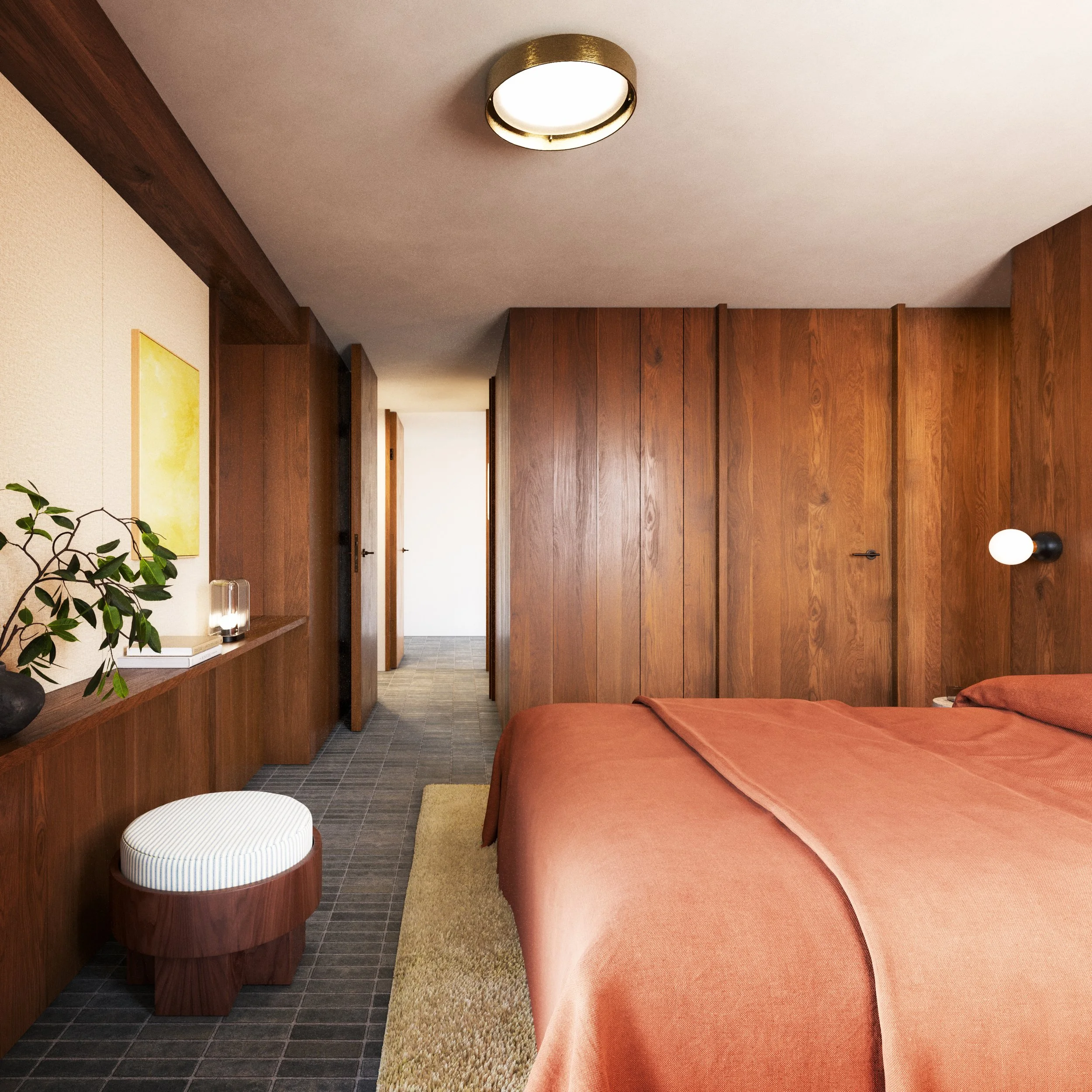 A bedroom with wood-paneled walls and a bed with rust-colored bedding. There is a small, round striped stool next to a built-in wooden shelf with plants and decorative items. The ceiling has a circular light fixture, and a wall-mounted lamp is next to the bed. A doorway leads to a bright corridor.