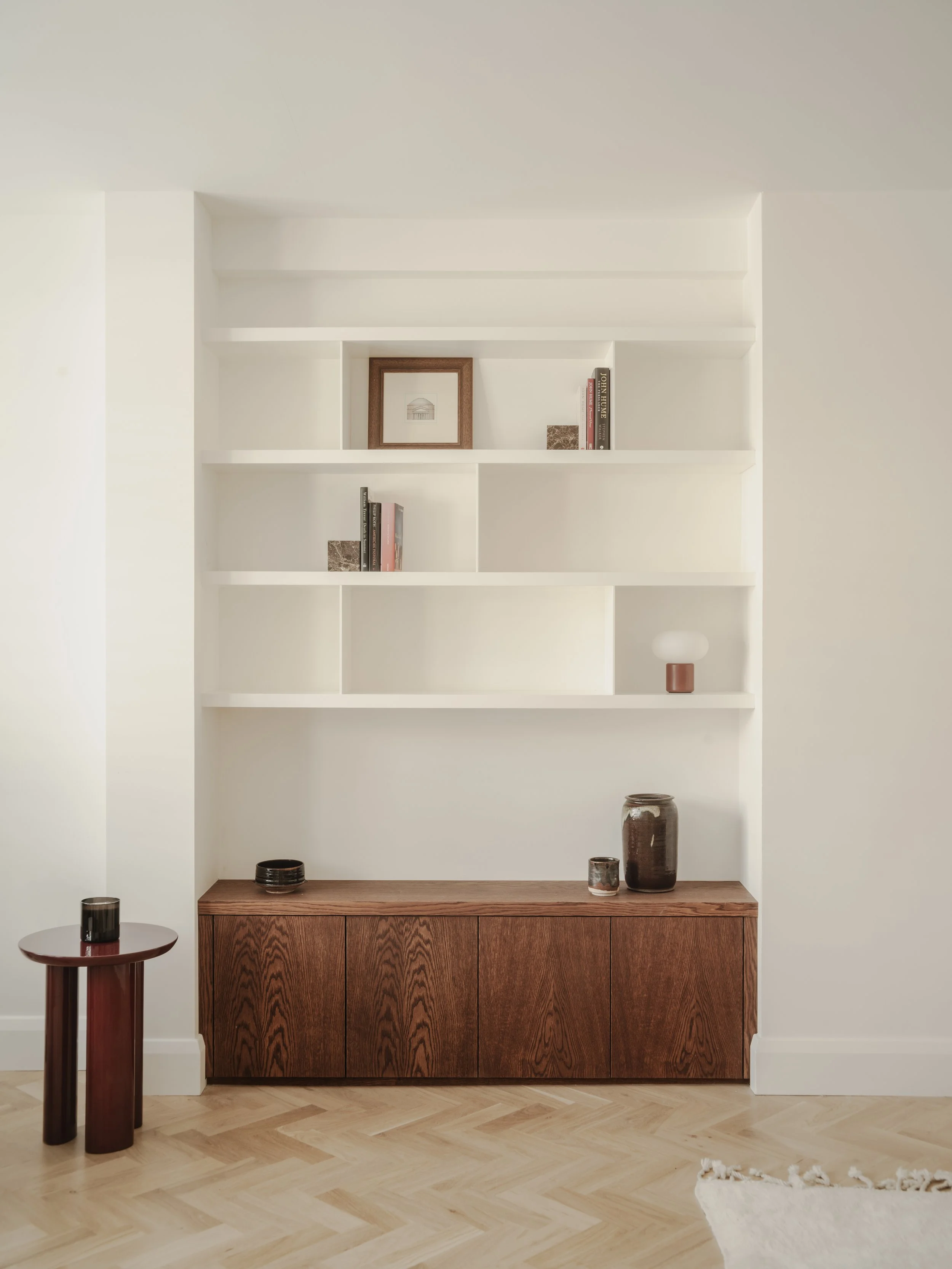 Living room with white built-in shelves, a wooden cabinet, and decorative vases on the cabinet and side table.