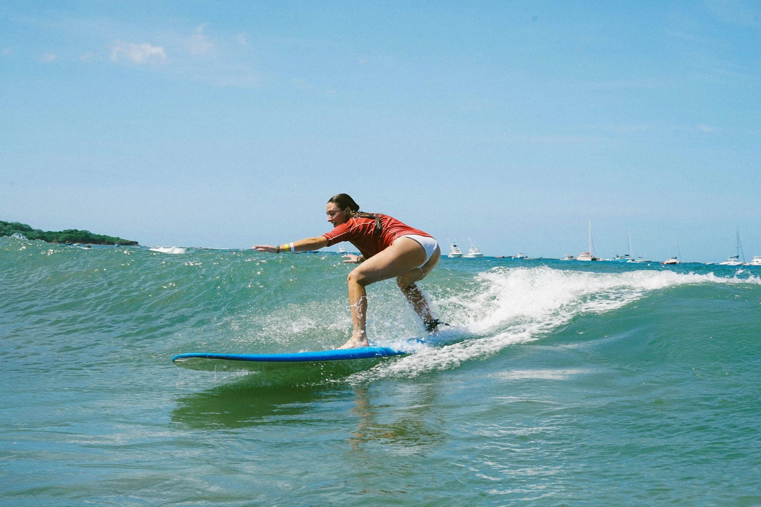 A beginner surfer learning on the calm waves of Tamarindo beach
