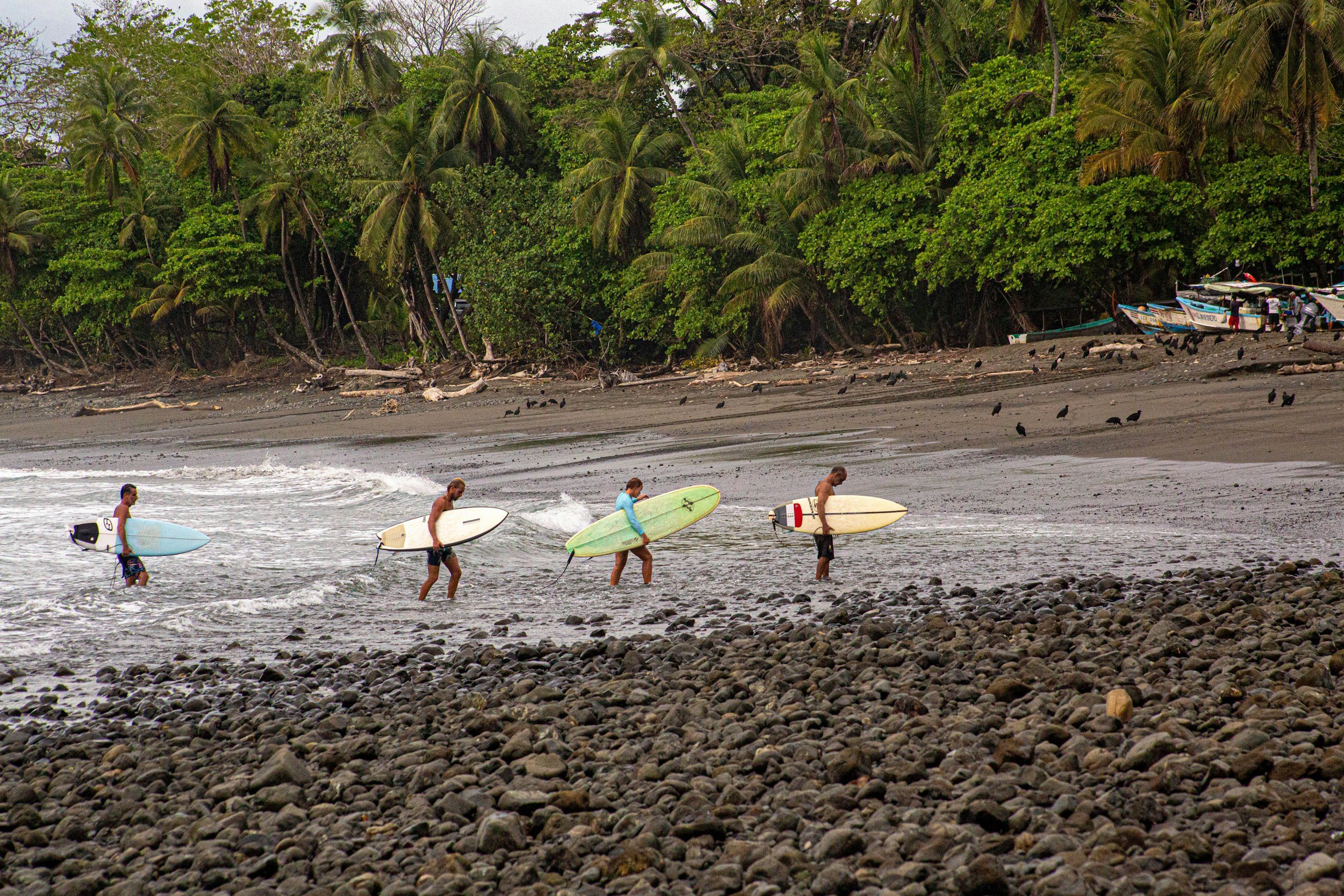Surfers come in after riding the long wave at Pavones
