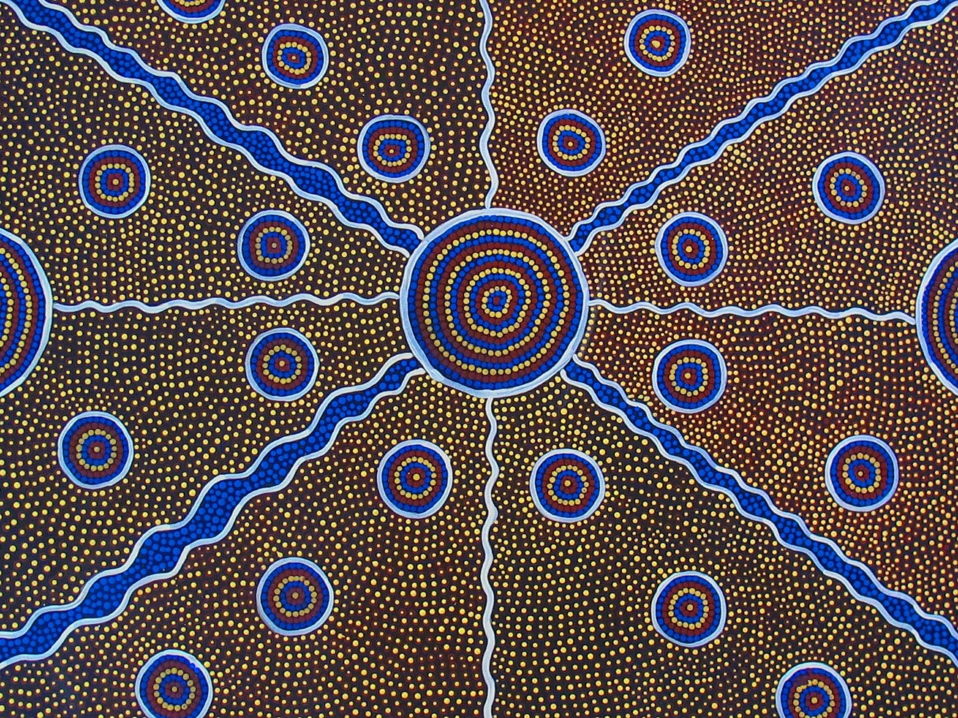 A colorful Aboriginal dot painting artwork featuring concentric circles connected by wavy lines, with a background filled with small, evenly spaced yellow dots on a dark base.
