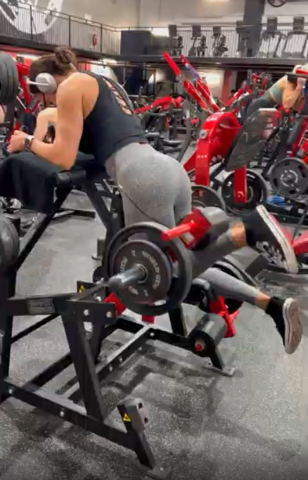 Woman performing strength training in a gym, focused on consistency and sustainable progress