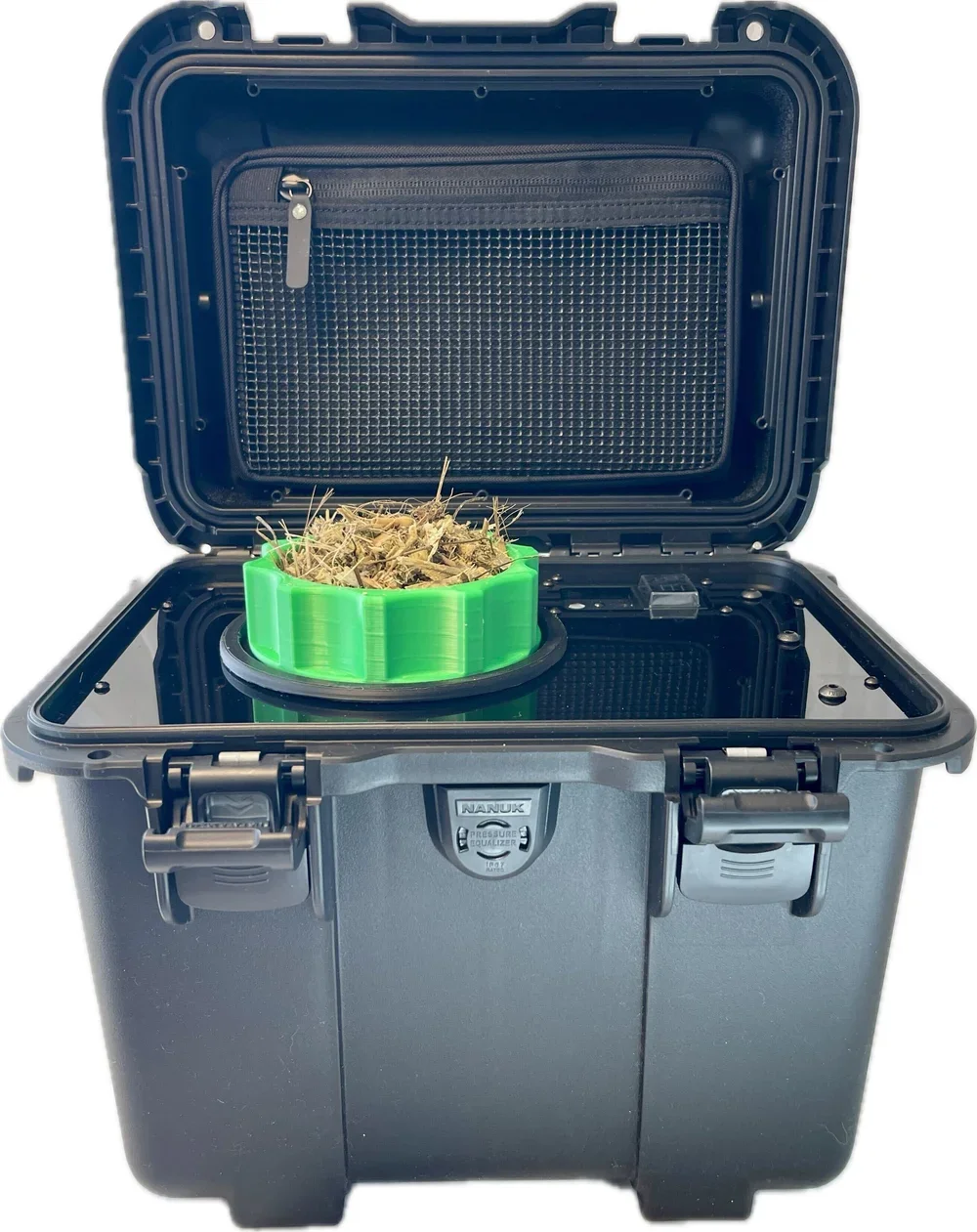 A black dry storage container with an open lid, containing a green circular container filled with dried plant material.