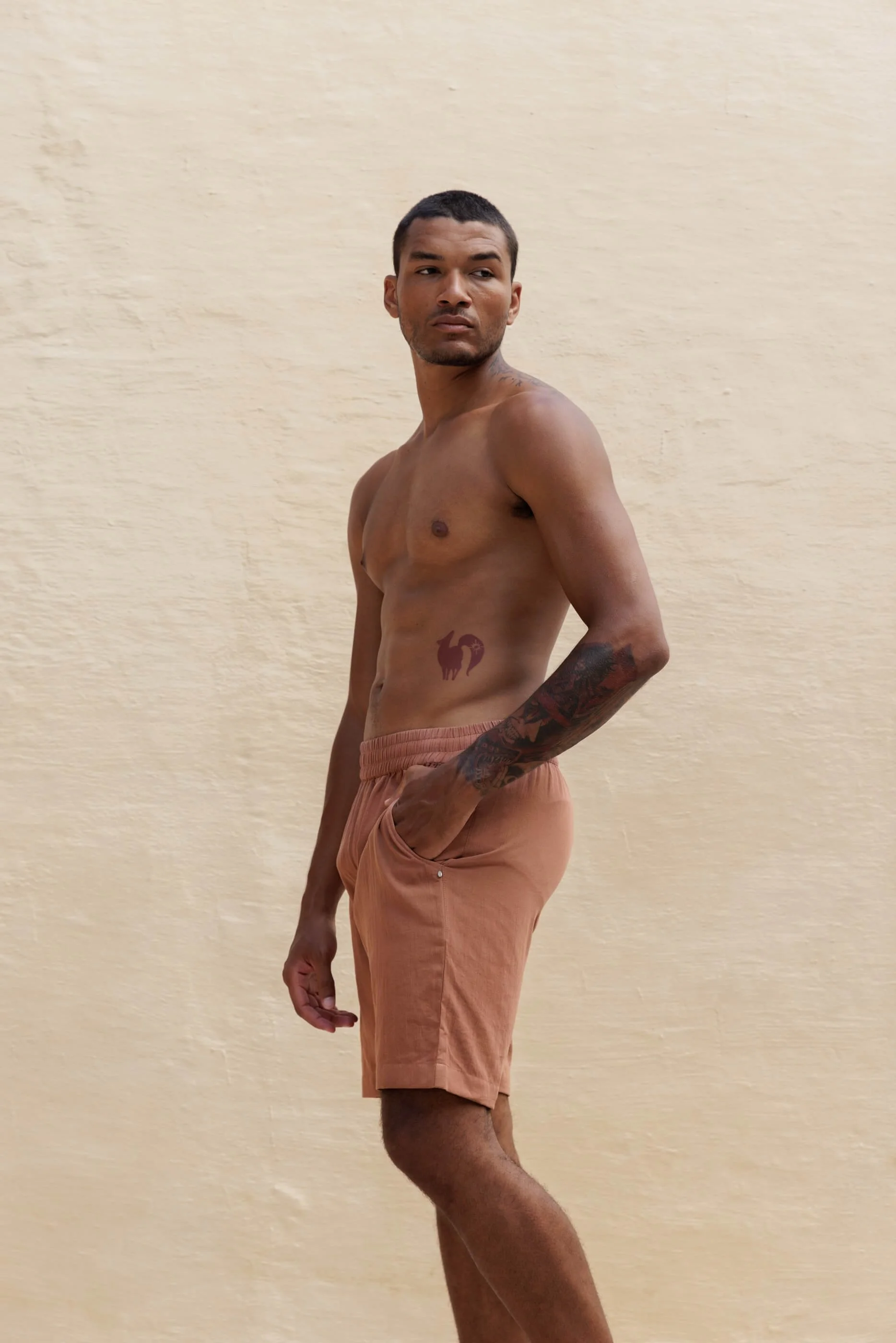 Side view of the lightweight Renclì cotton shorts in Terra Stone, emphasizing the sporty, contemporary cut and the soft texture of the stonewashed fabric.
