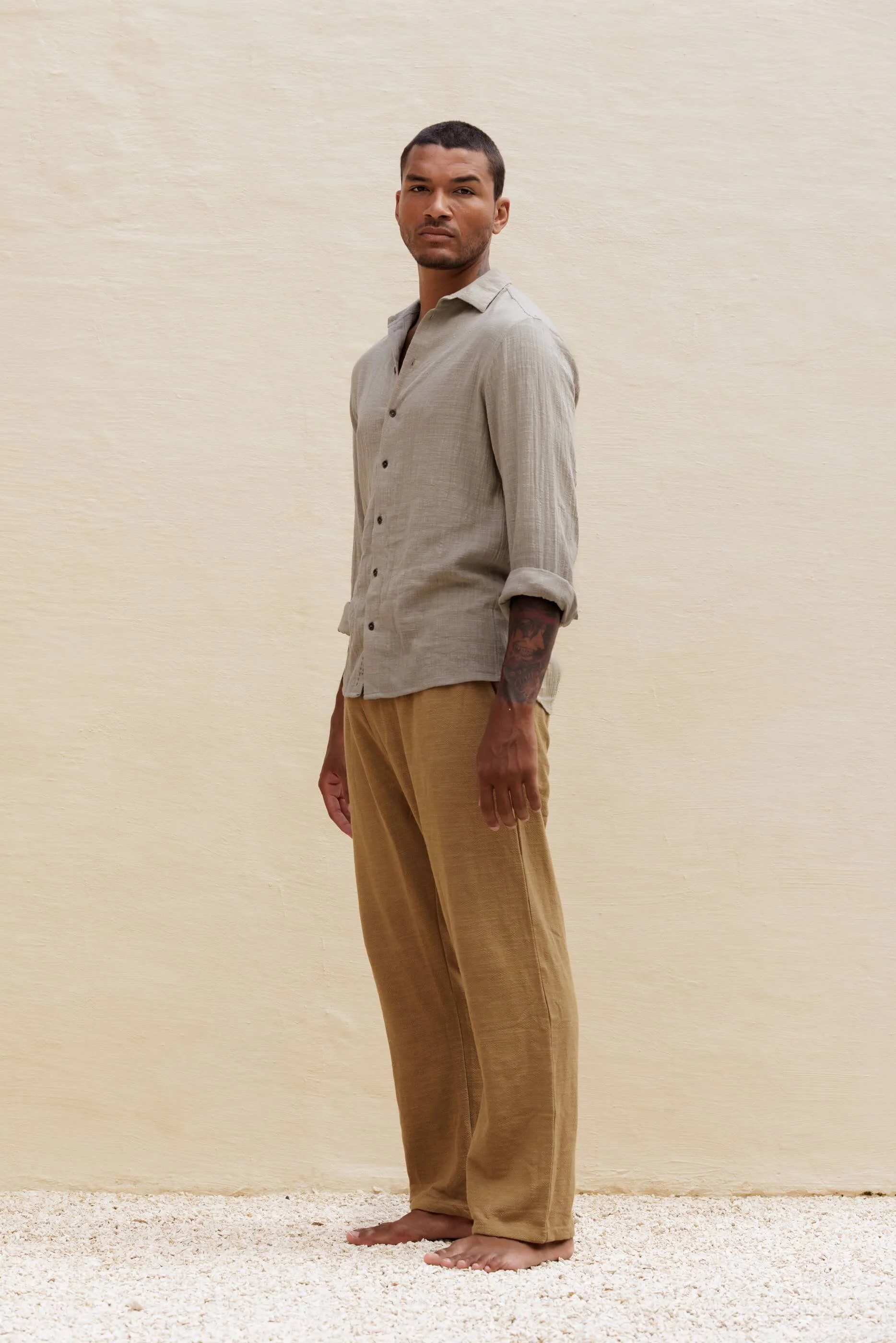 Full-length three-quarter front view of the Mateu shirt outfit in Sahara beige and dust olive green trousers, highlighting a sophisticated, artisanal leisurewear look.