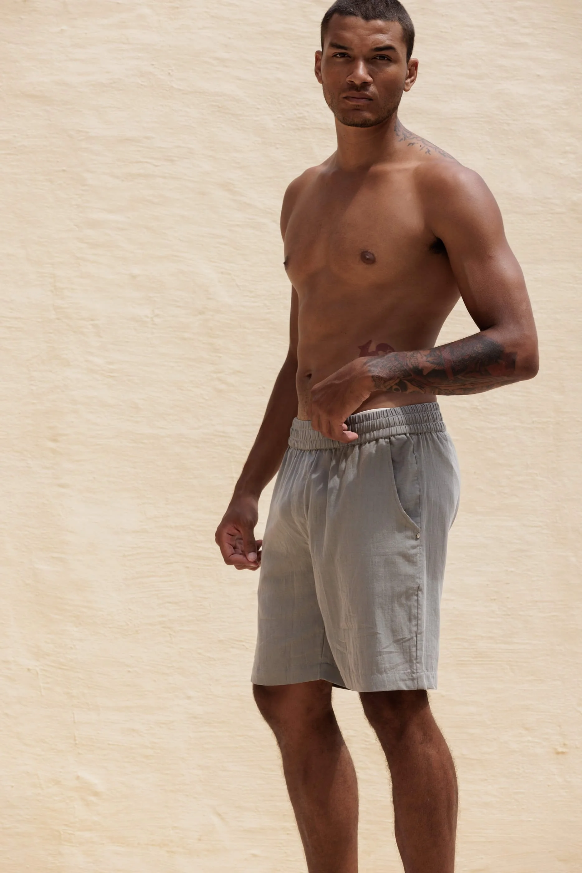 A closer full-length three-quarter front view of the Renclì shorts in Sage Stone, highlighting the comfortable leg design, elastic waistband.