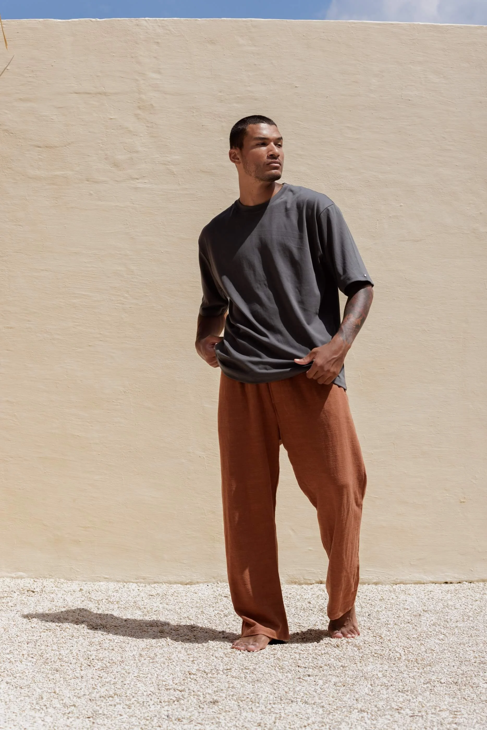 Full-length front view of the Benirras Terracotta trousers styled with the premium Gael T-shirt in Metal blue-grey, showcasing a sophisticated contrast of warm and cool tones.