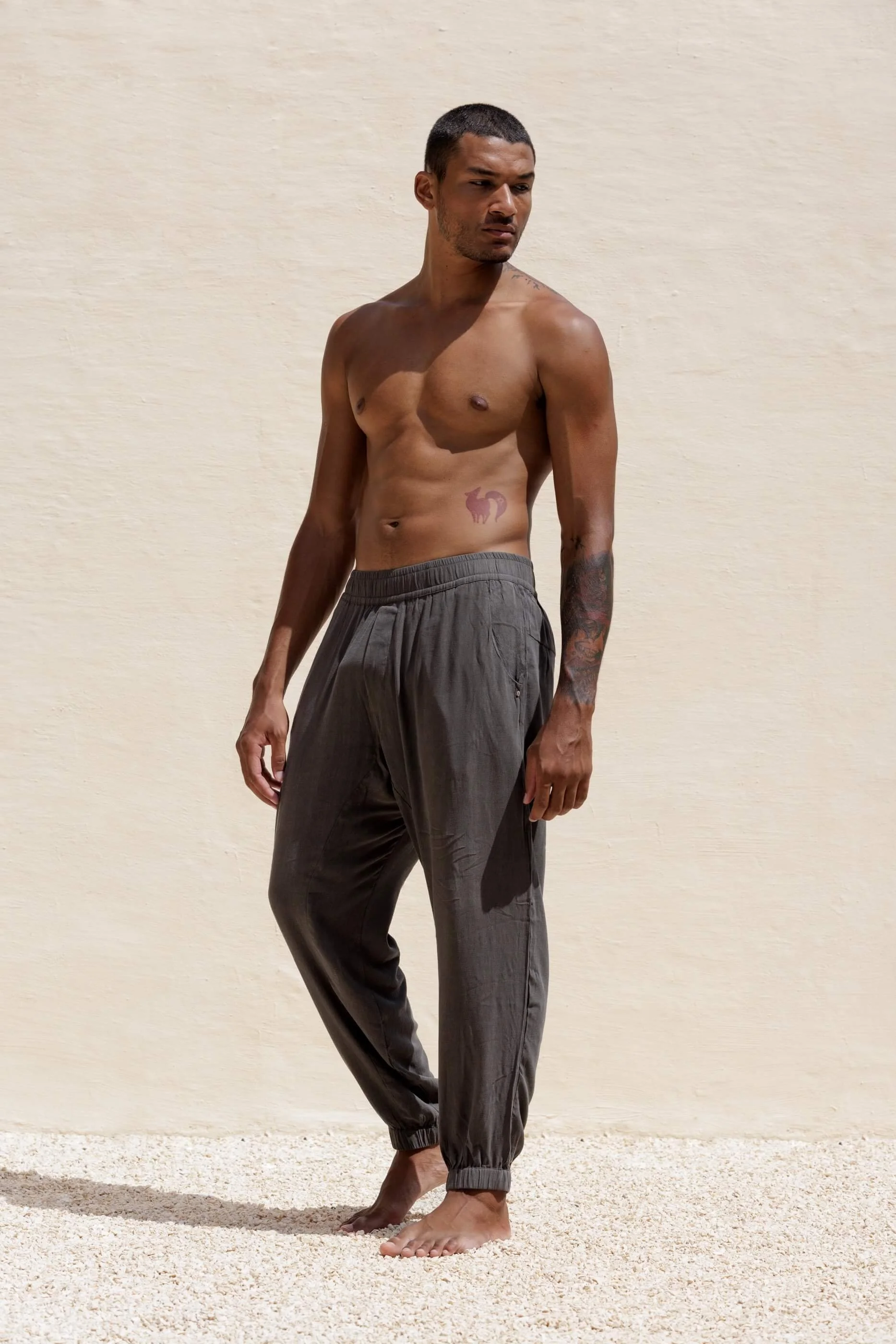 Three-quarter view from the waist down of Gracio trousers in Dust Grey Tencel, highlighting the fluid drape and comfortable elastic waistband.