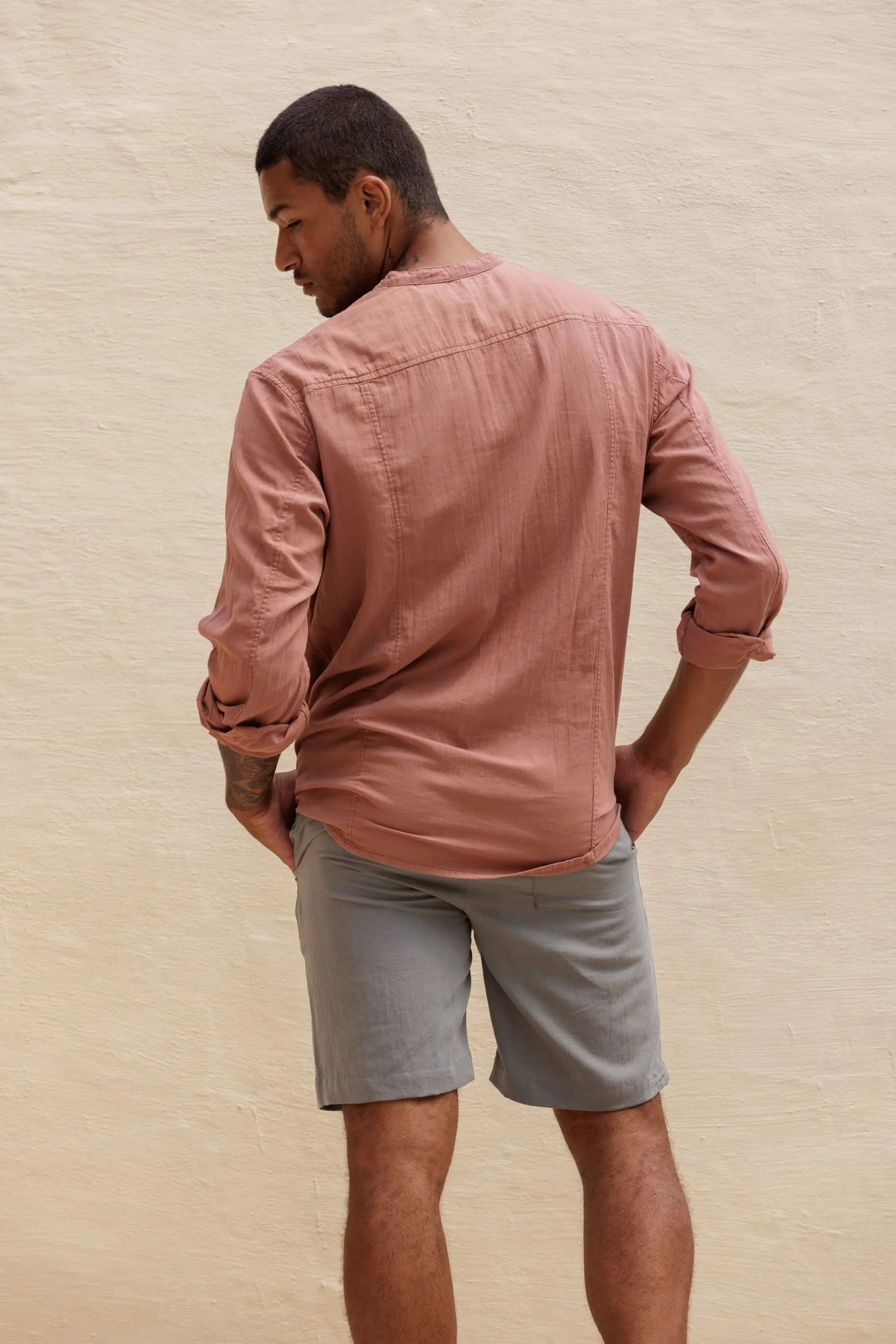 Rear view of the lightweight Jordi shirt in Terra Stone paired with the Renclì shorts in Sage Stone, highlighting the relaxed fit and the clean draped silhouette of the stonewashed cotton ensemble.