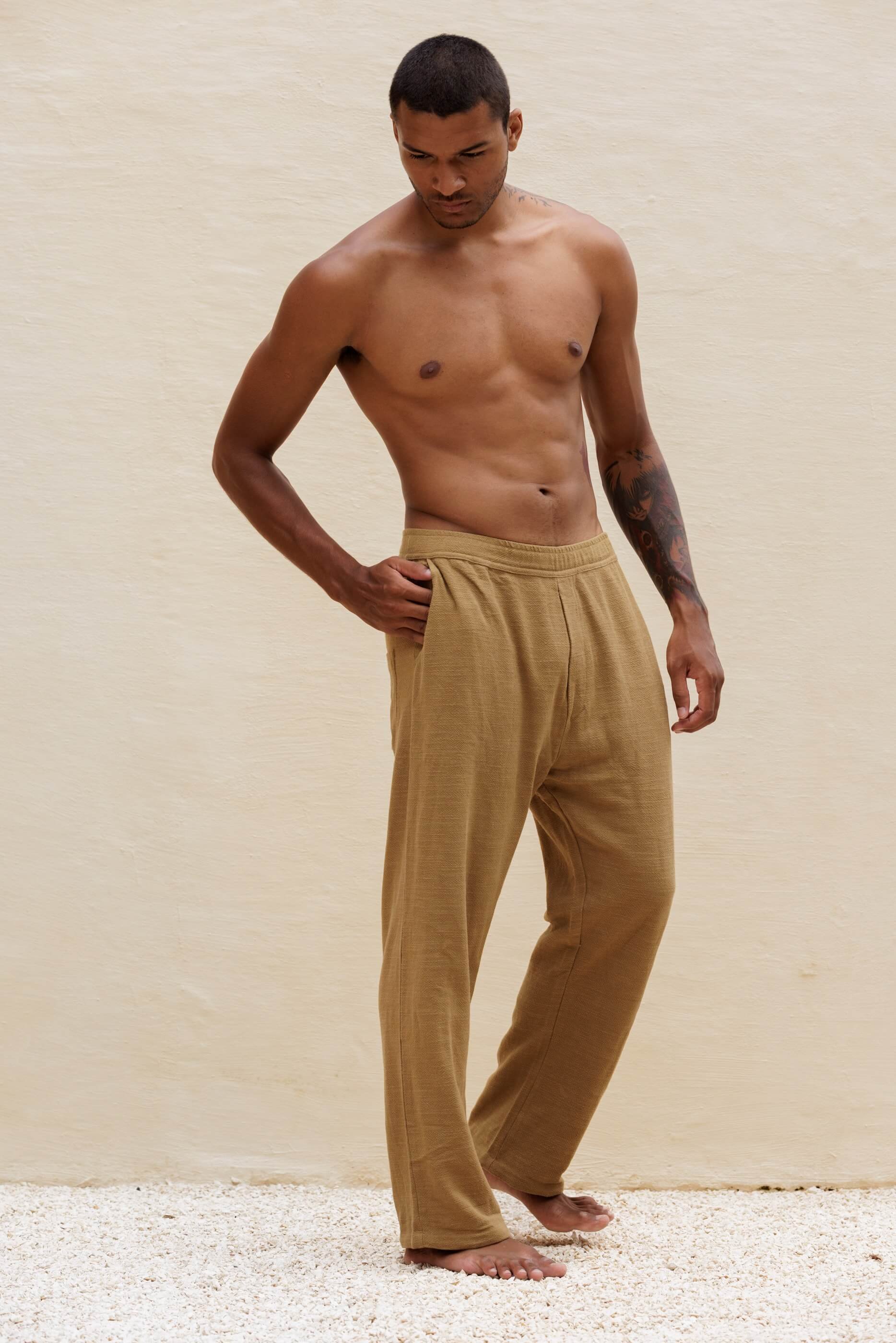 Full-length three-quarter front view of the model wearing the Benirras trousers in Dust Olive Green, showcasing the soft fluid drape and straight-leg silhouette.