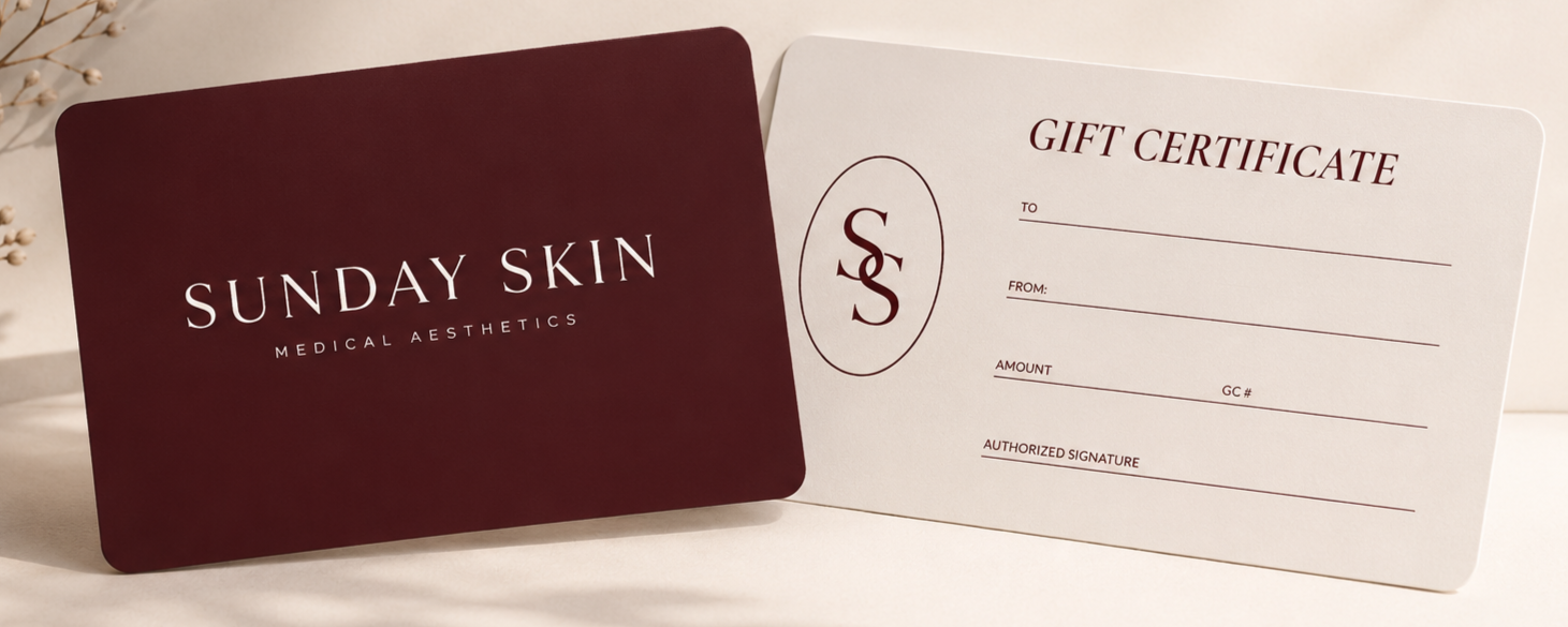 A gift card from Sunday Skin with a maroon front and white interior, alongside a blank gift certificate form, on a white surface with some decorative elements in the background.