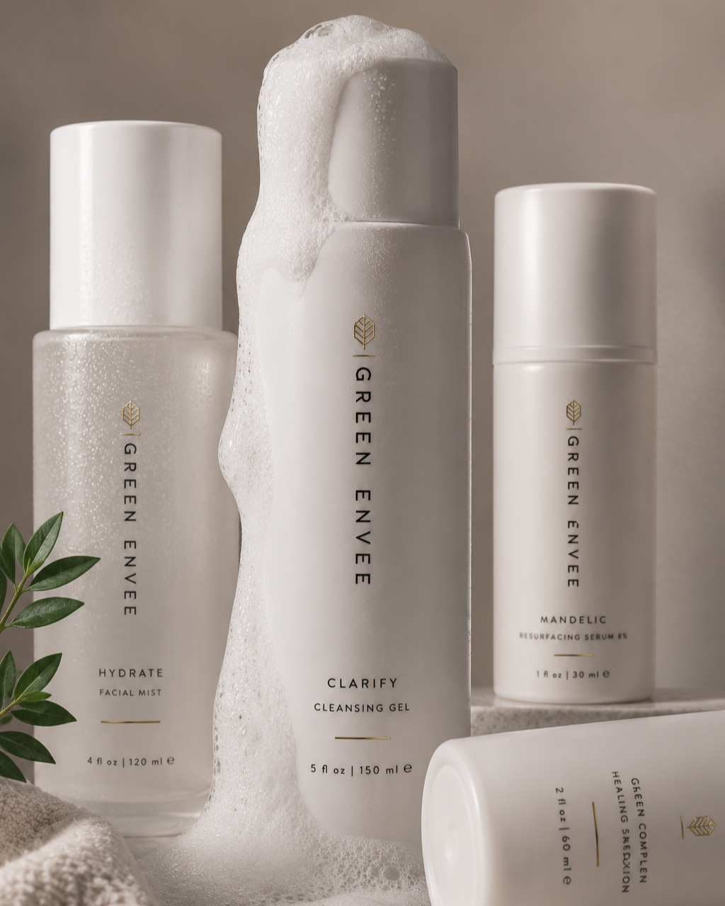 Collection of skincare products from Green Envee, including Clarify Cleansing Gel, Hydrate Facial Mist, Mandelic Resurfacing Serum, and Healing Serum, with foam suds on the gel container.