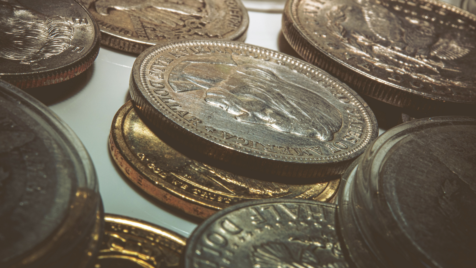 Close-up of various coins, including pennies and other currency, scattered and stacked.