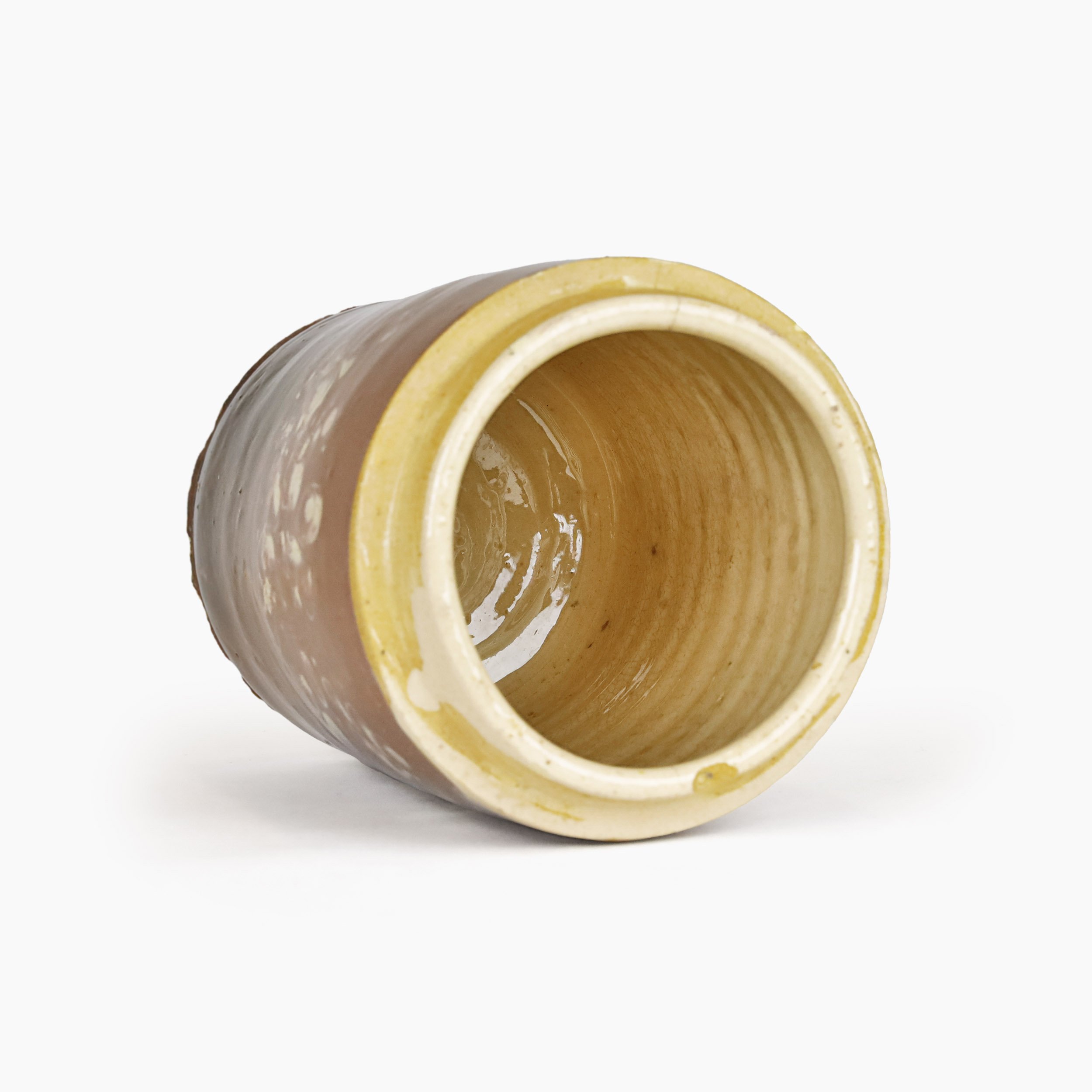 Pot ancien couché pour montrer son intérieur émaillé couleur beurre frais