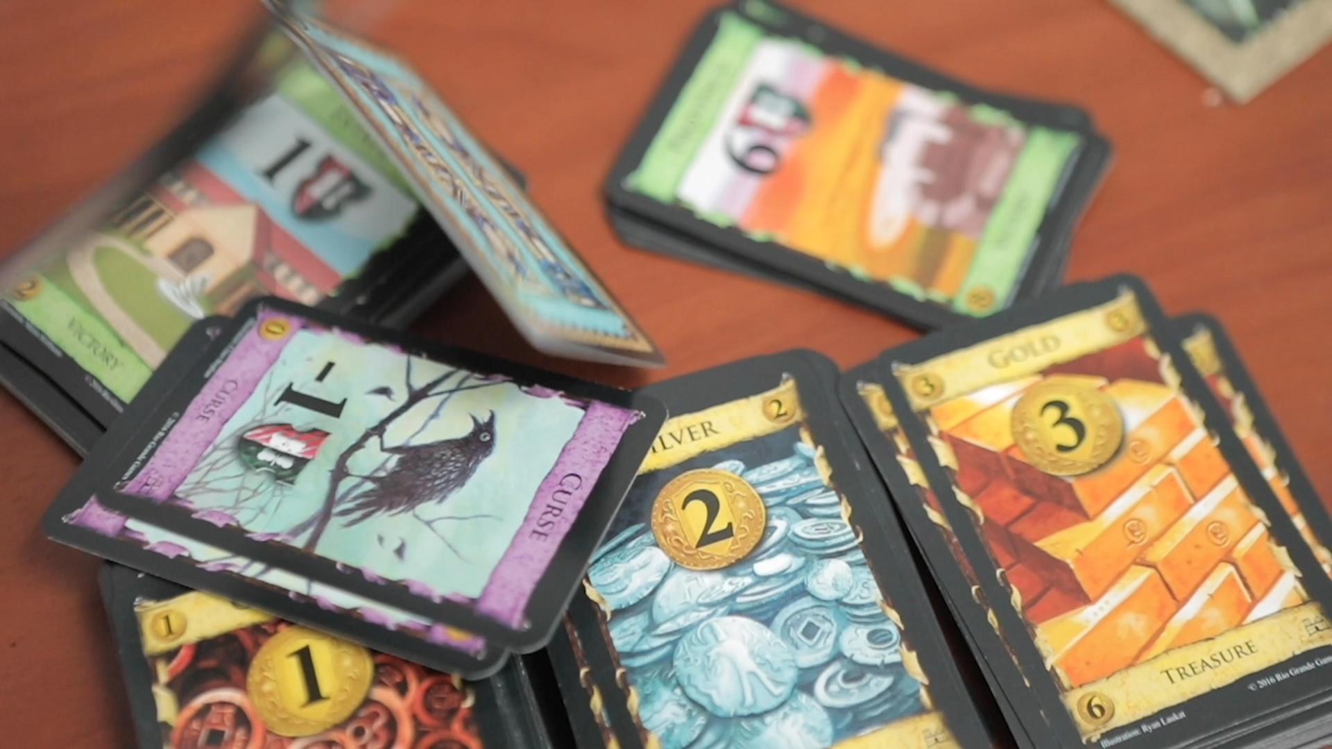 Build your deck, full of 3 types of main cards. Avoid the curses.