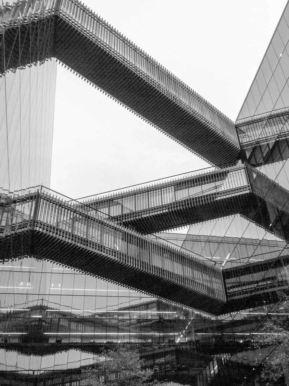 Black and white photo of modern architectural building with multiple suspended walkways and glass walls representing data and insights.