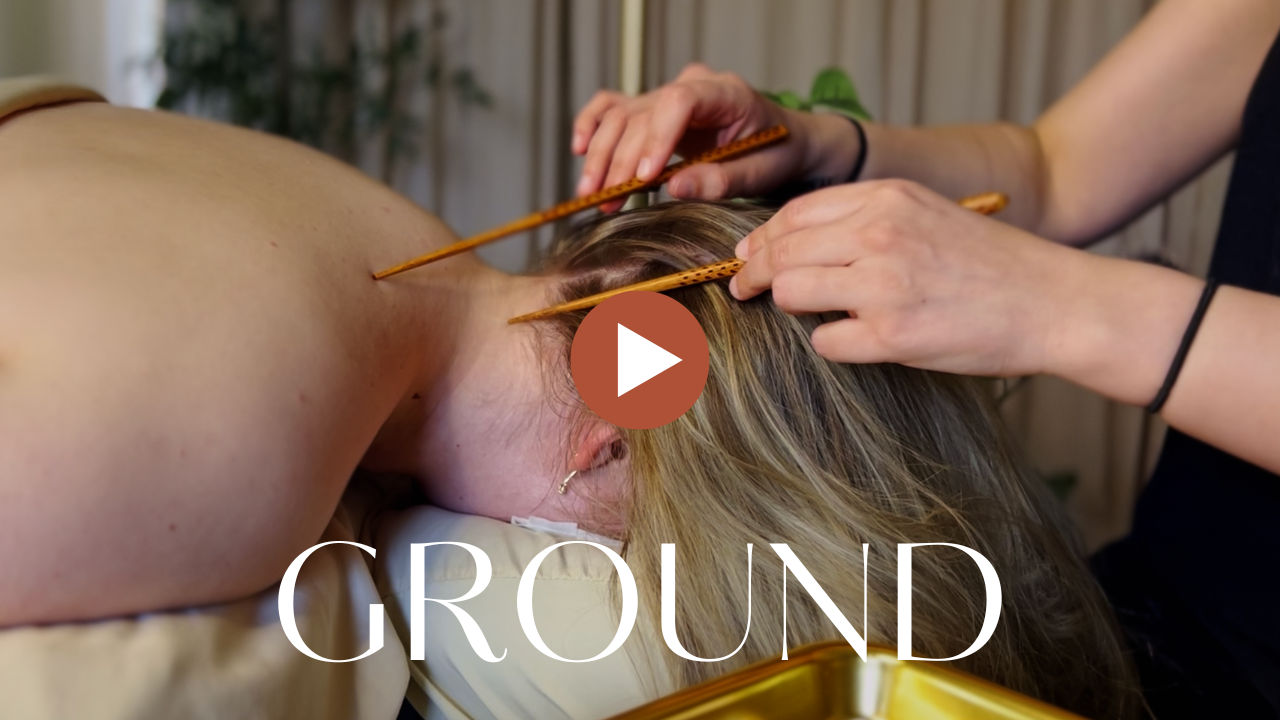 Massage therapist performing a head and neck acupuncture treatment on a woman lying face down.