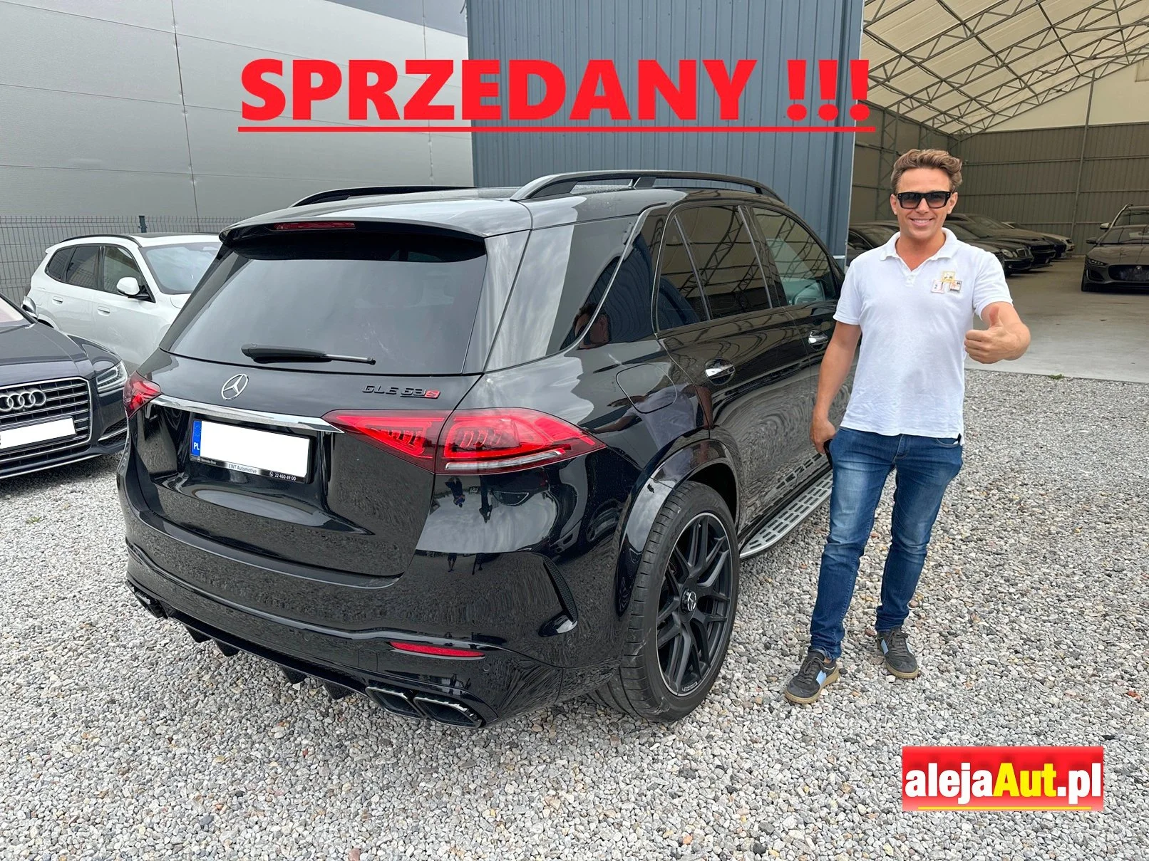 A man in sunglasses and a white polo shirt giving a thumbs-up next to a black Mercedes-Benz GLE 53S SUV with the word "SPRZEDANY" and exclamation marks in red text at the top, and a red and yellow alejaAut.pl logo at the bottom right.