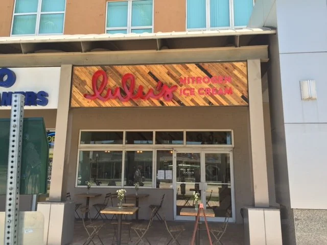 Wood art paneled restaurant neon exterior sign board at Lulu's Nitrogen Ice Cream shop. 
