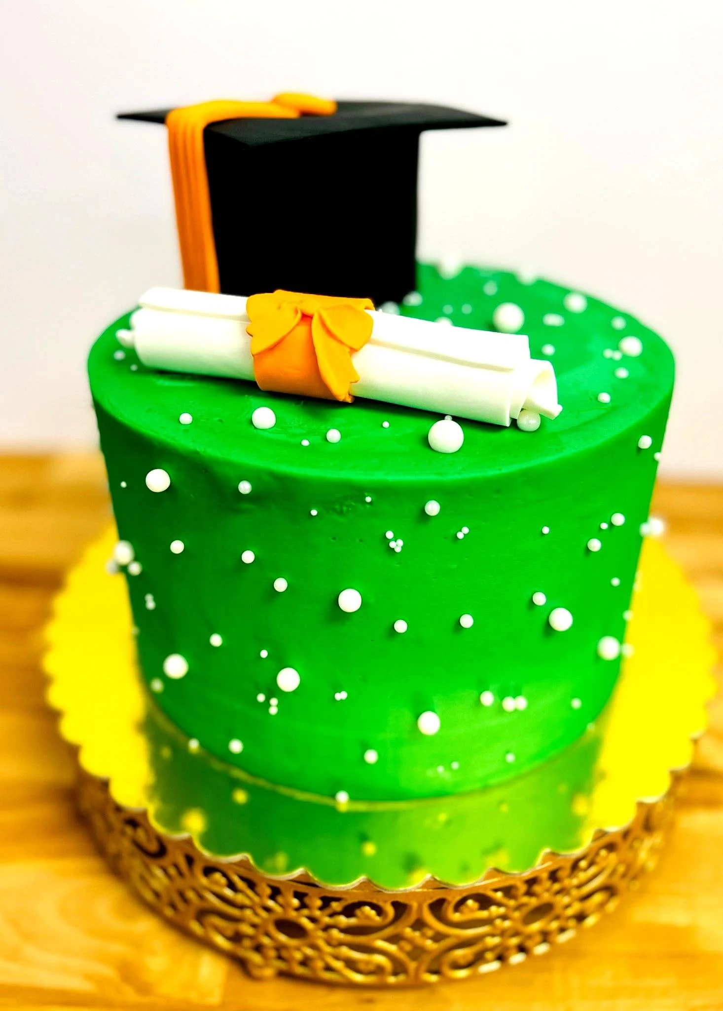 Green cake with graduation cap and diploma decoration