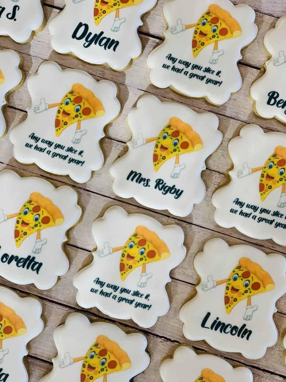 Decorated cookies with cute pizza slice graphics, personalized names, and the phrase "Any way you slice it, we had a great year!"