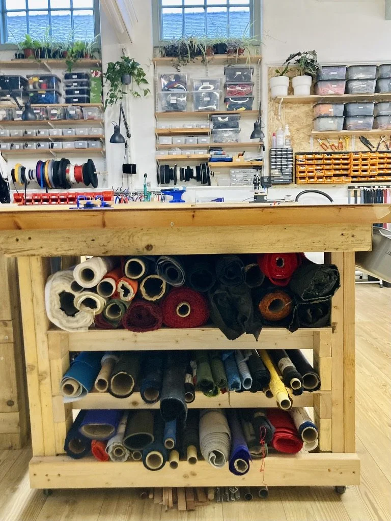 Rolls of fabric stored underneath a cutting table