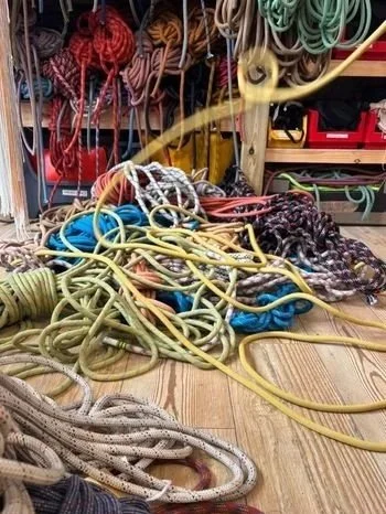 a tangle of colourful dynamic ropes lay in a heap on the workshop floor, which is laminate