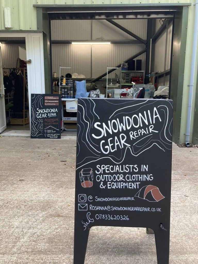 sign for specialist in outdoor clothing repair, in front of warehouse space