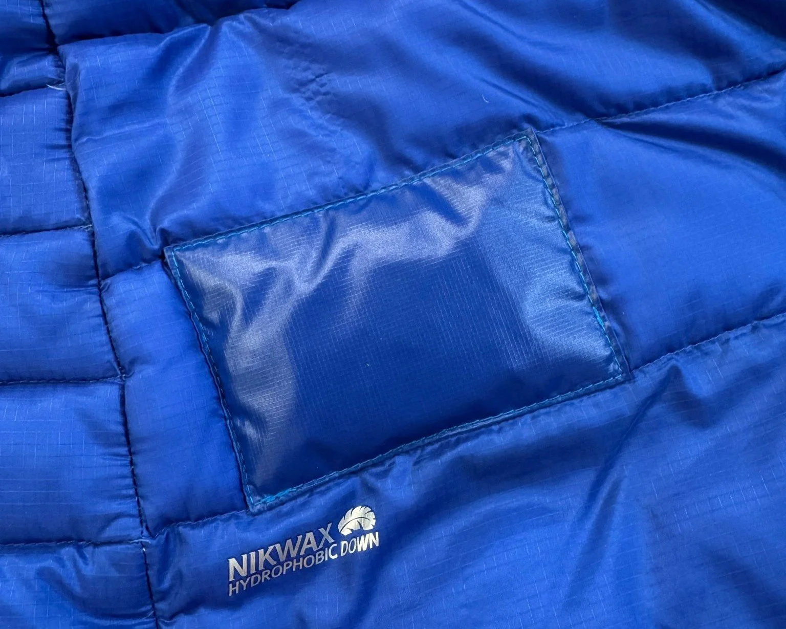 nikwax hydrophobic down jacket with blue sewn patch