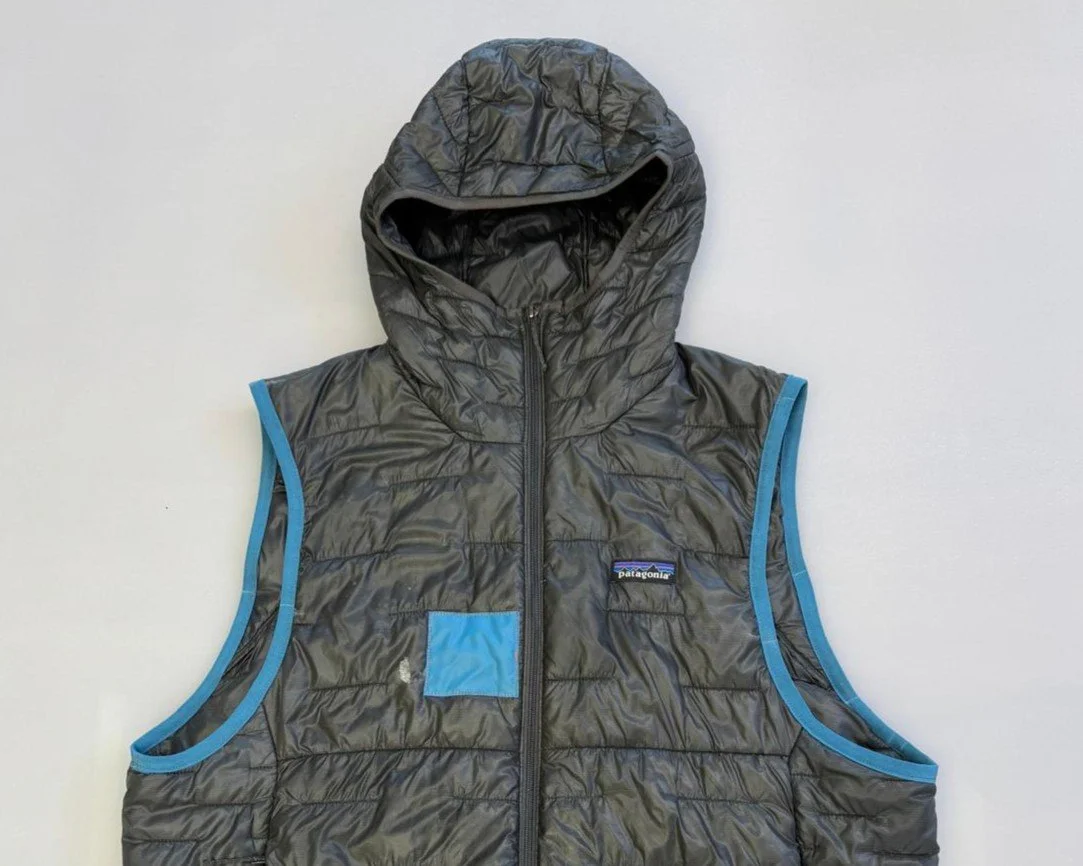 patagonia gilet with blue binding and a matching blue patch 