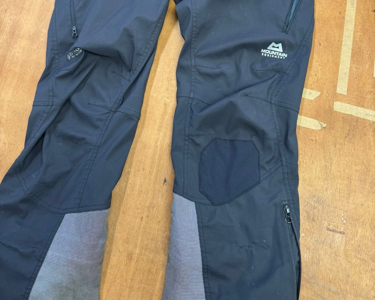 Mountain equipment waterproof trousers with a sewn patch on them