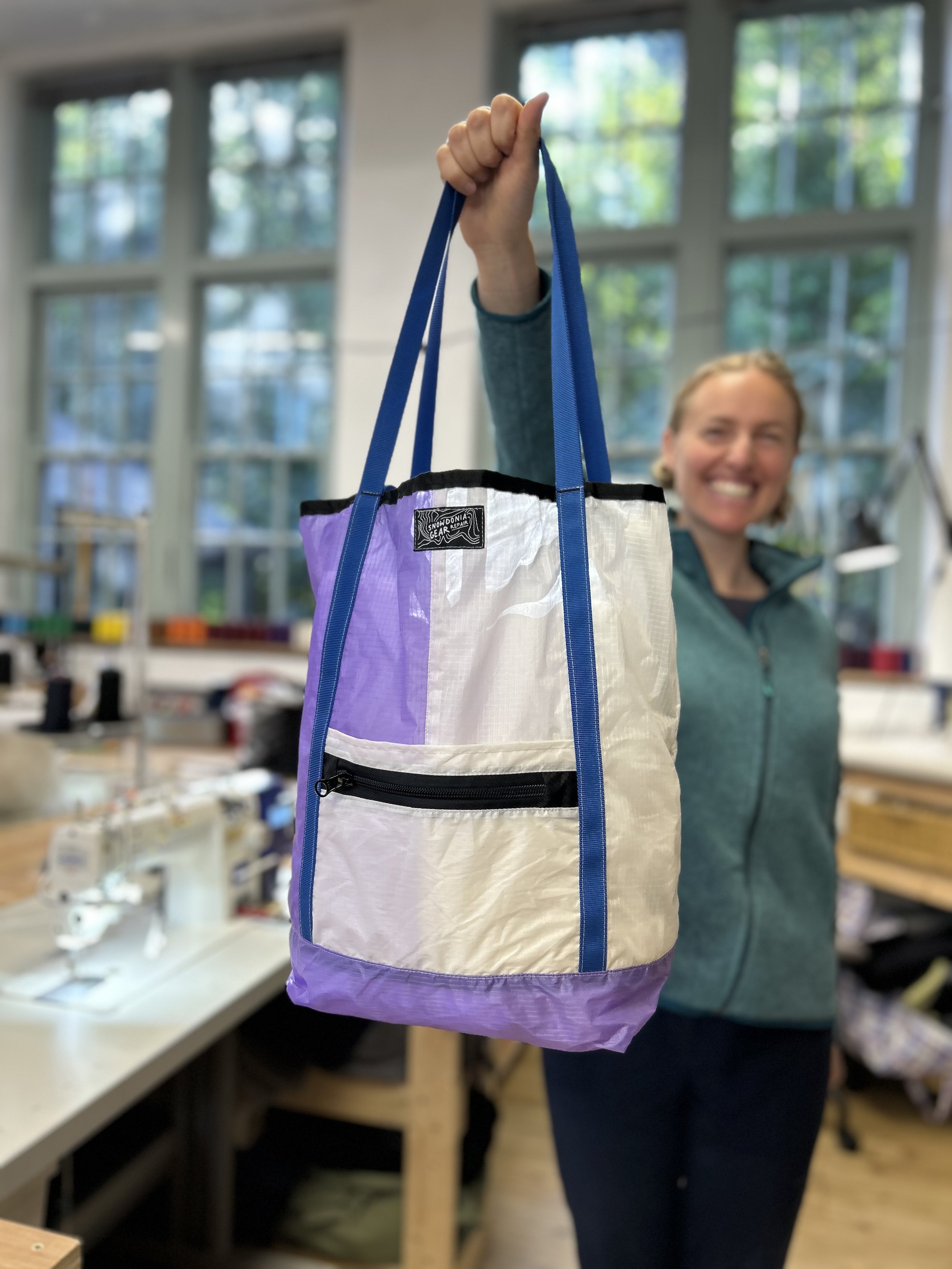 smiling-woman-proudly-holding-tote-bag.jpeg