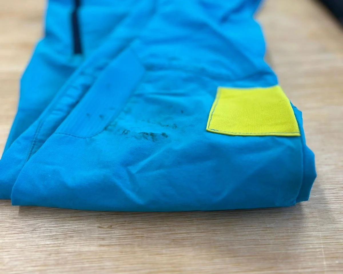 climbing trousers folded on cutting table with bright yellow patch
