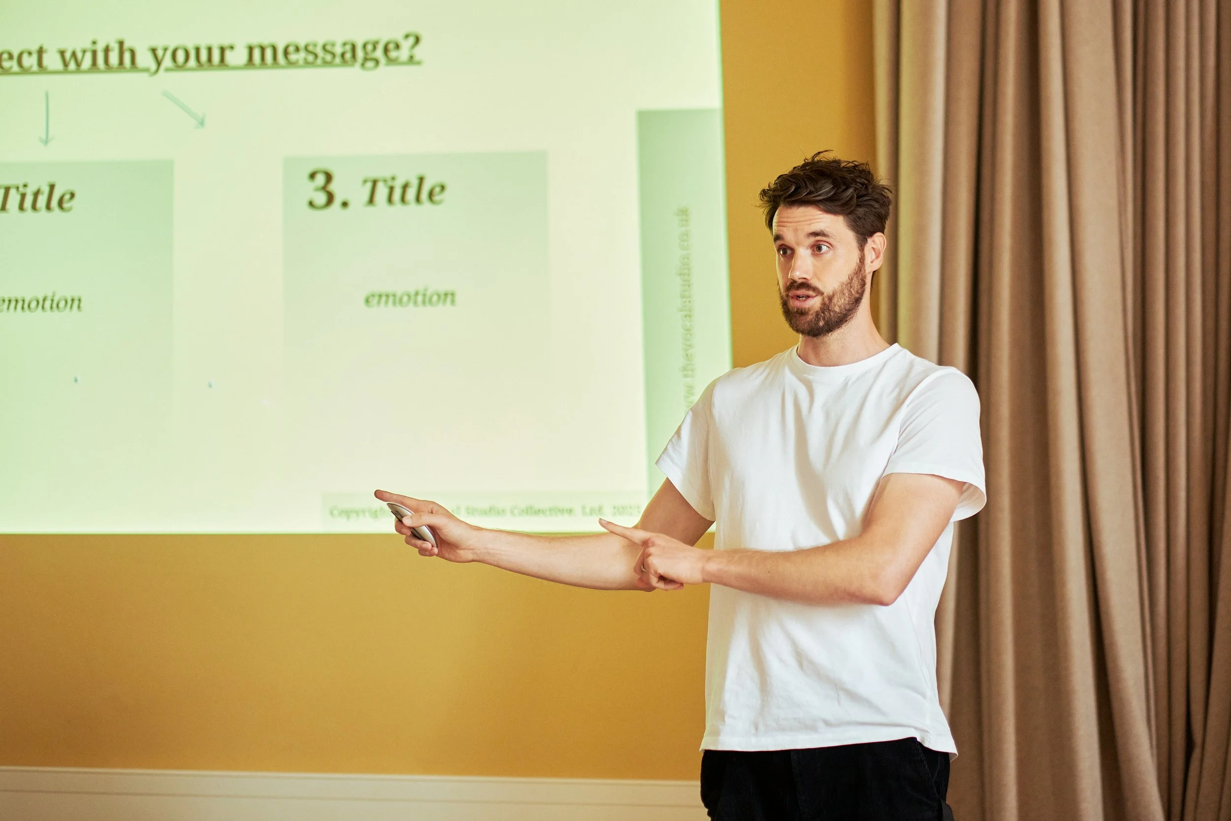A man standing in front of a presentation teaching a group