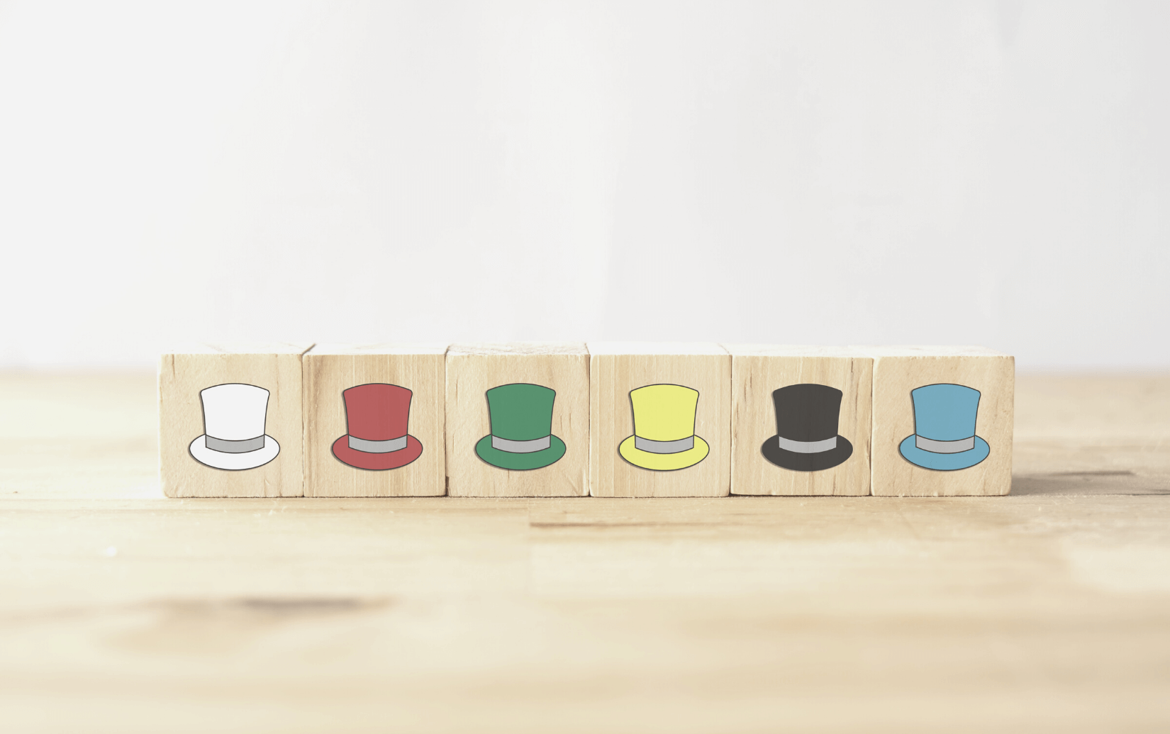 a row of six top hats in different colors