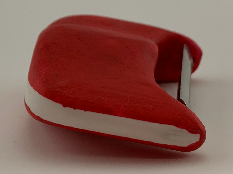 Close-up of a red plastic hand-held pencil sharpener with a metal blade.