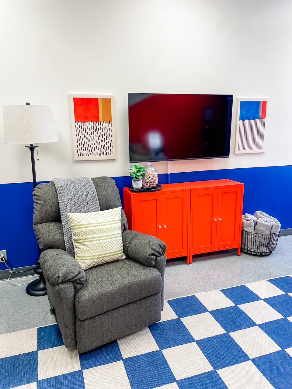 The glider provides sensory support and also opens into a recliner. The cabinets provide storage for electronics and toys.