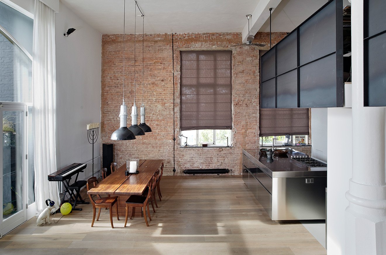 Canal House Amsterdam exposed red warehouse brickwork surrounding the dining tabke.jpg