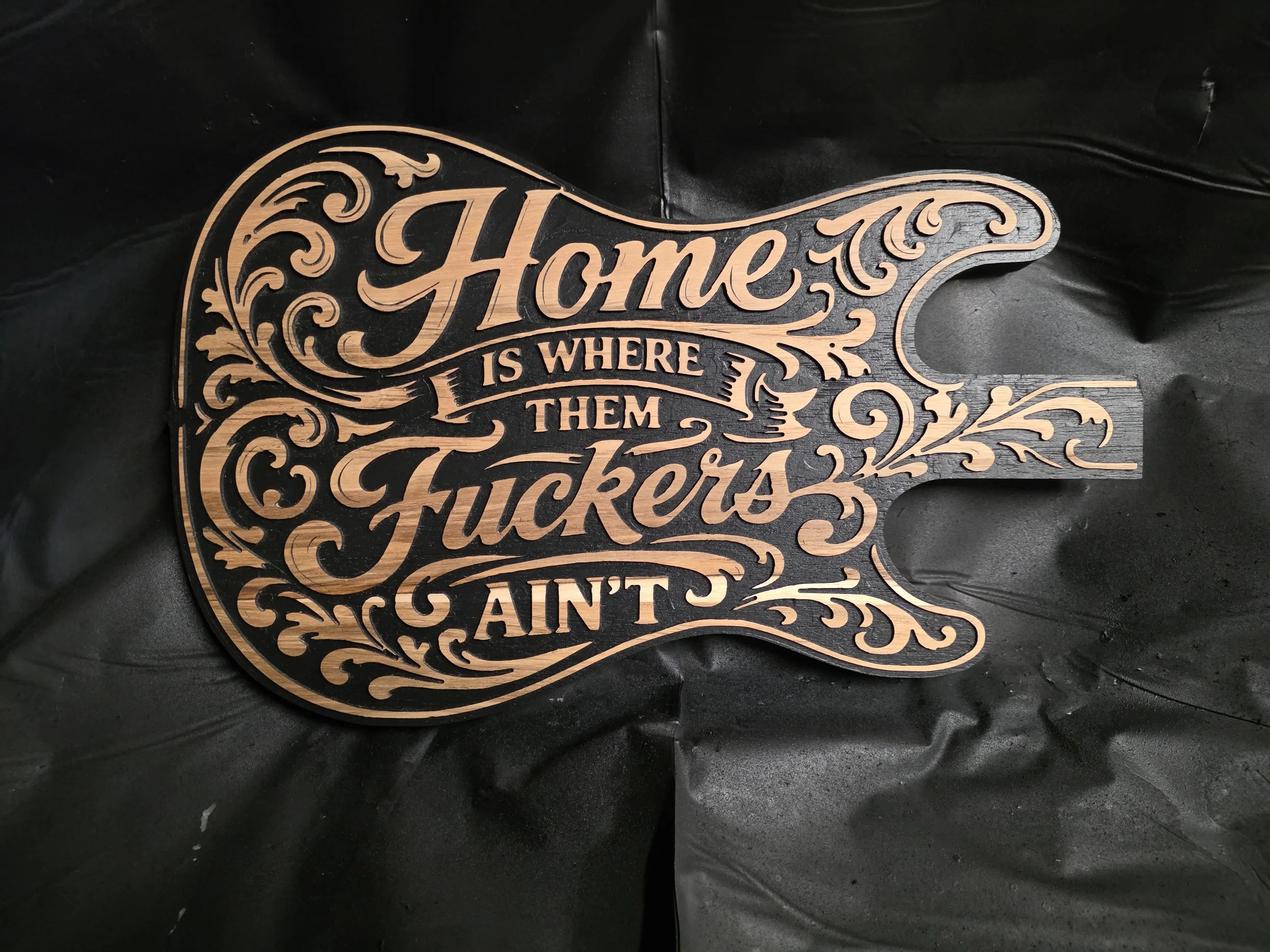 Decorative wood sign with script typography and carved flourishes