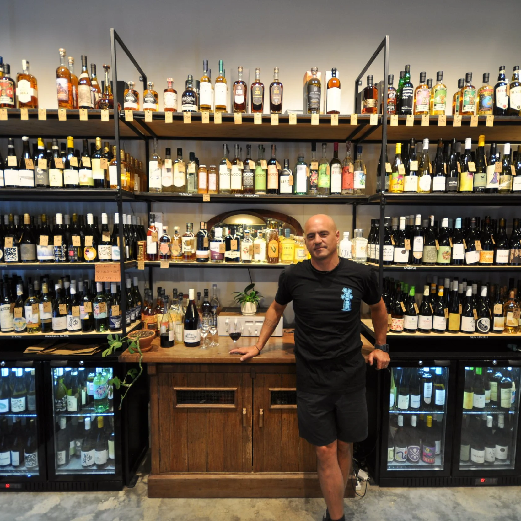 Benji from Upstairs Wines Ettalong, standing in his shop