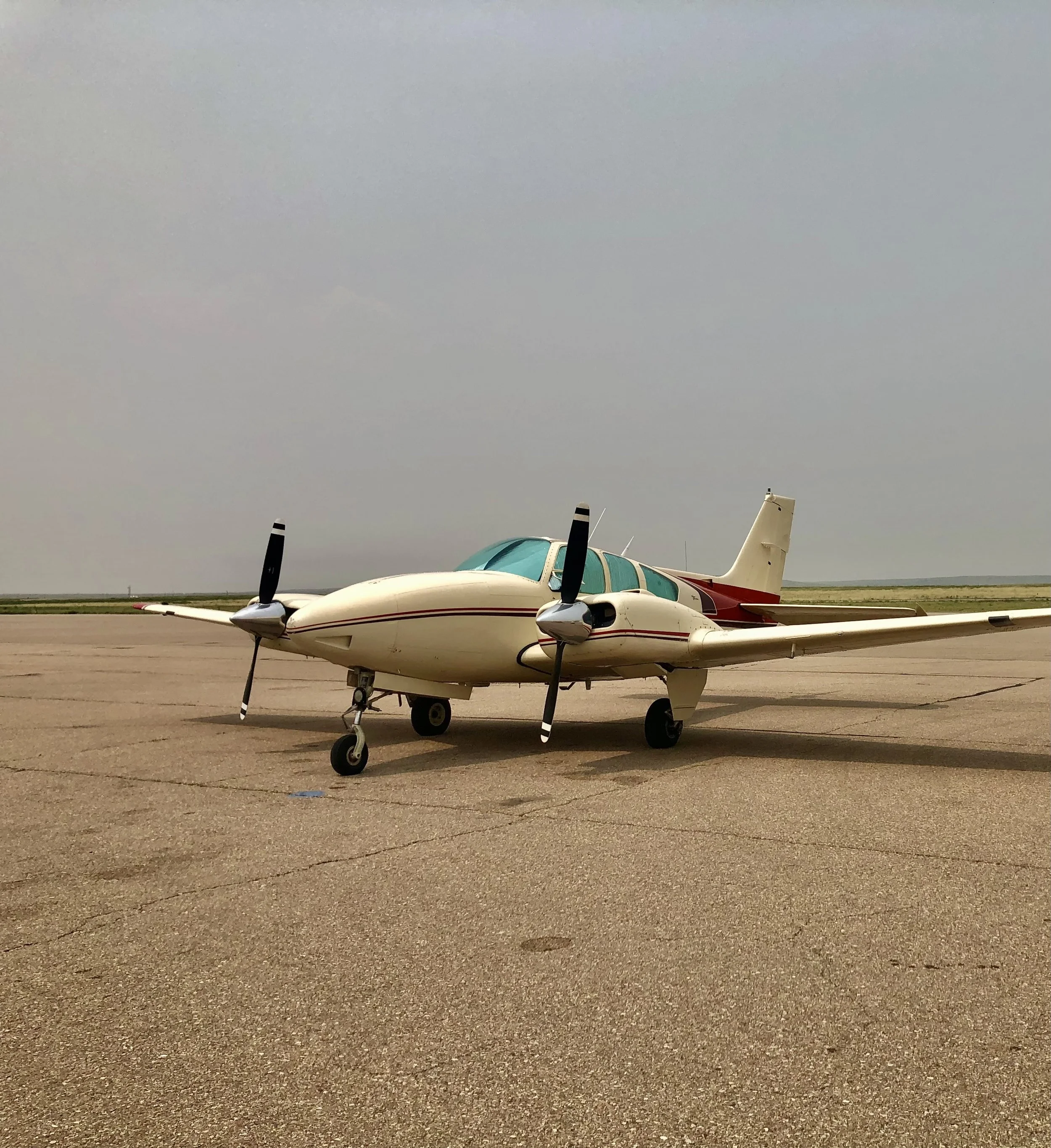 Wetsu Aviation Baron D55 N321N parked on the runway in bad weather