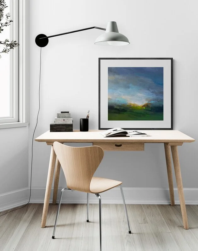 Abstract landscape painting on a table in an office with chair and lamp