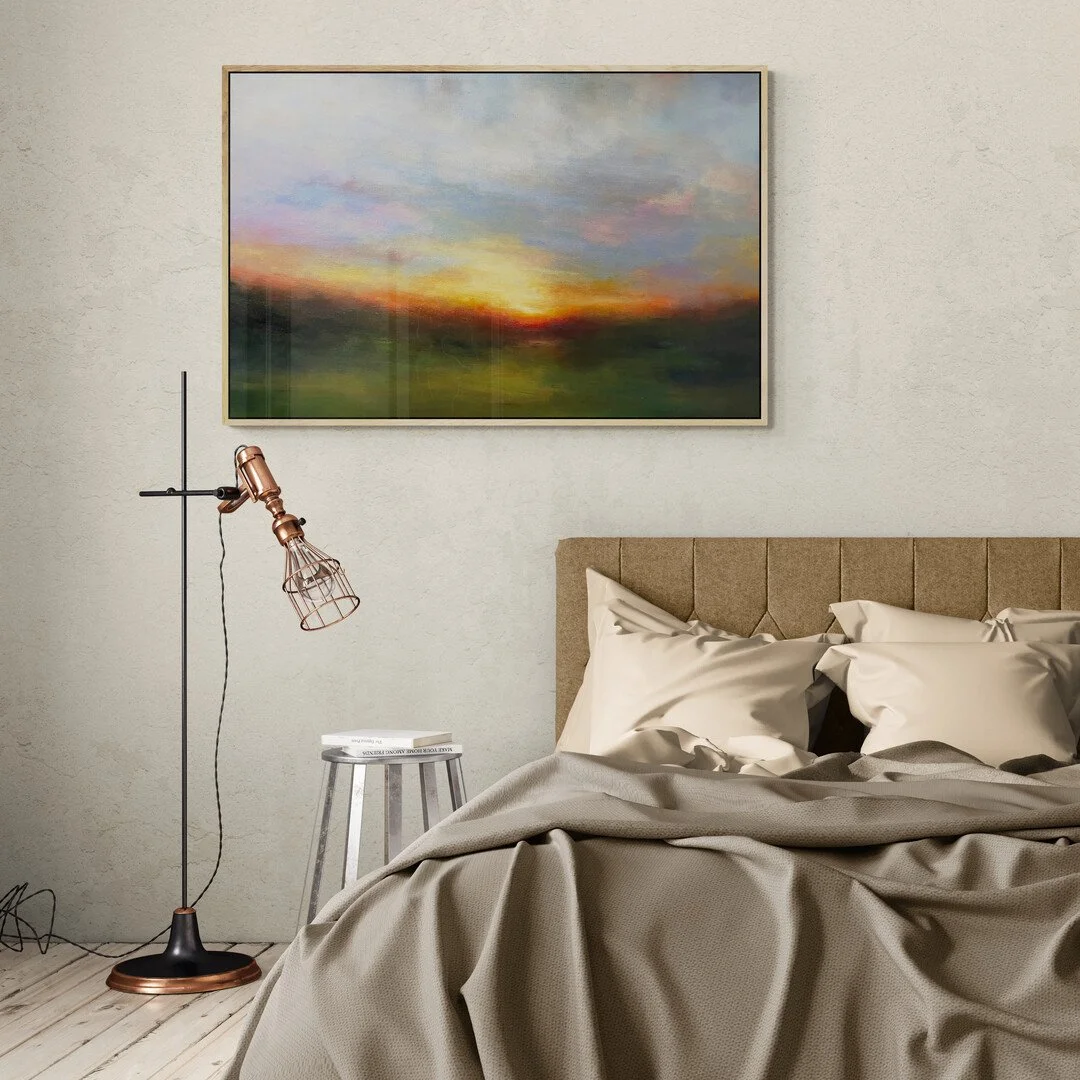 Evening Blush Impressionist pink sunset painting hanging on a wall above a bed with floor lamp by Mary Burtenshaw