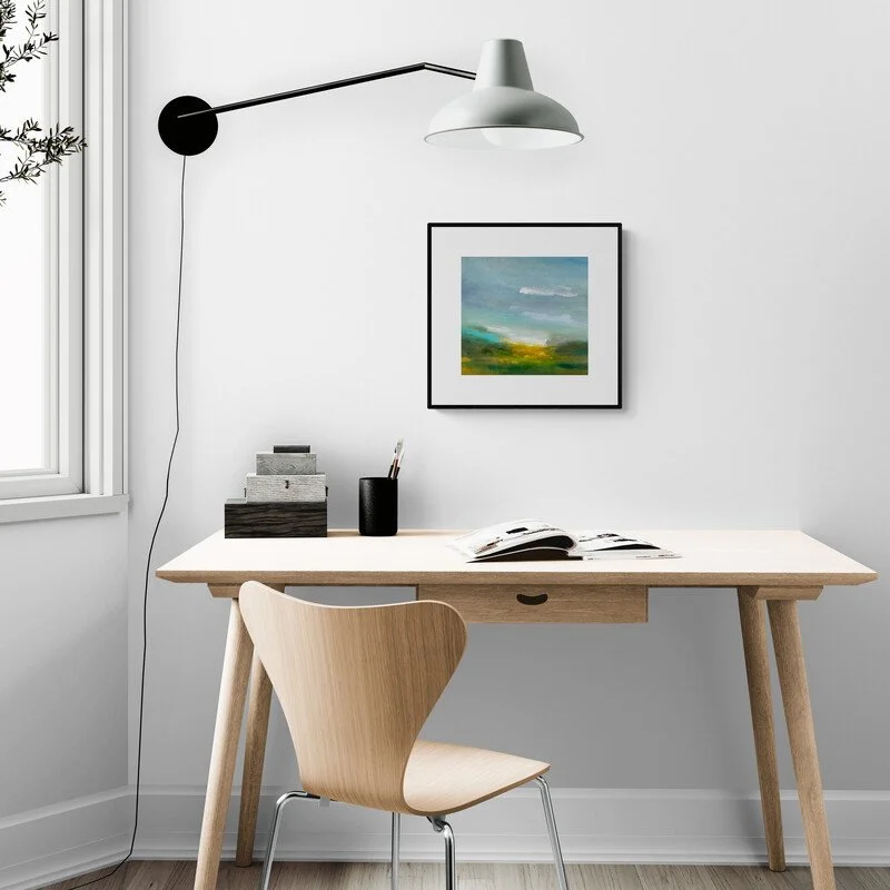 Sunlit Breath Abstract small painting on the wall of a home office with desk and chair and landscape painting in a frame on the wall.